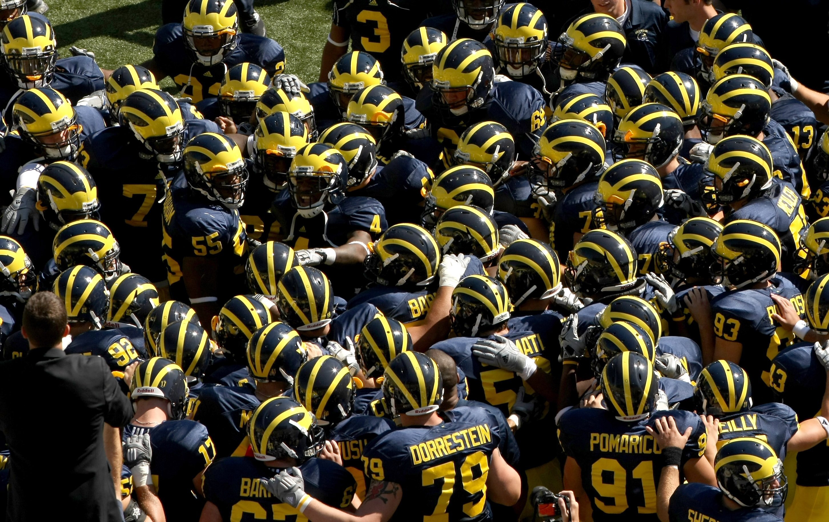 ANN ARBOR, MI - SEPTEMBER 19:  The Michigan Wolverines huddles on the field before the game against the Eastern Michigan Eagles at Michigan Stadium on September 19, 2009 in Ann Arbor, Michigan. Michigan won 45-17.  (Photo by Stephen Dunn/Getty Images)
