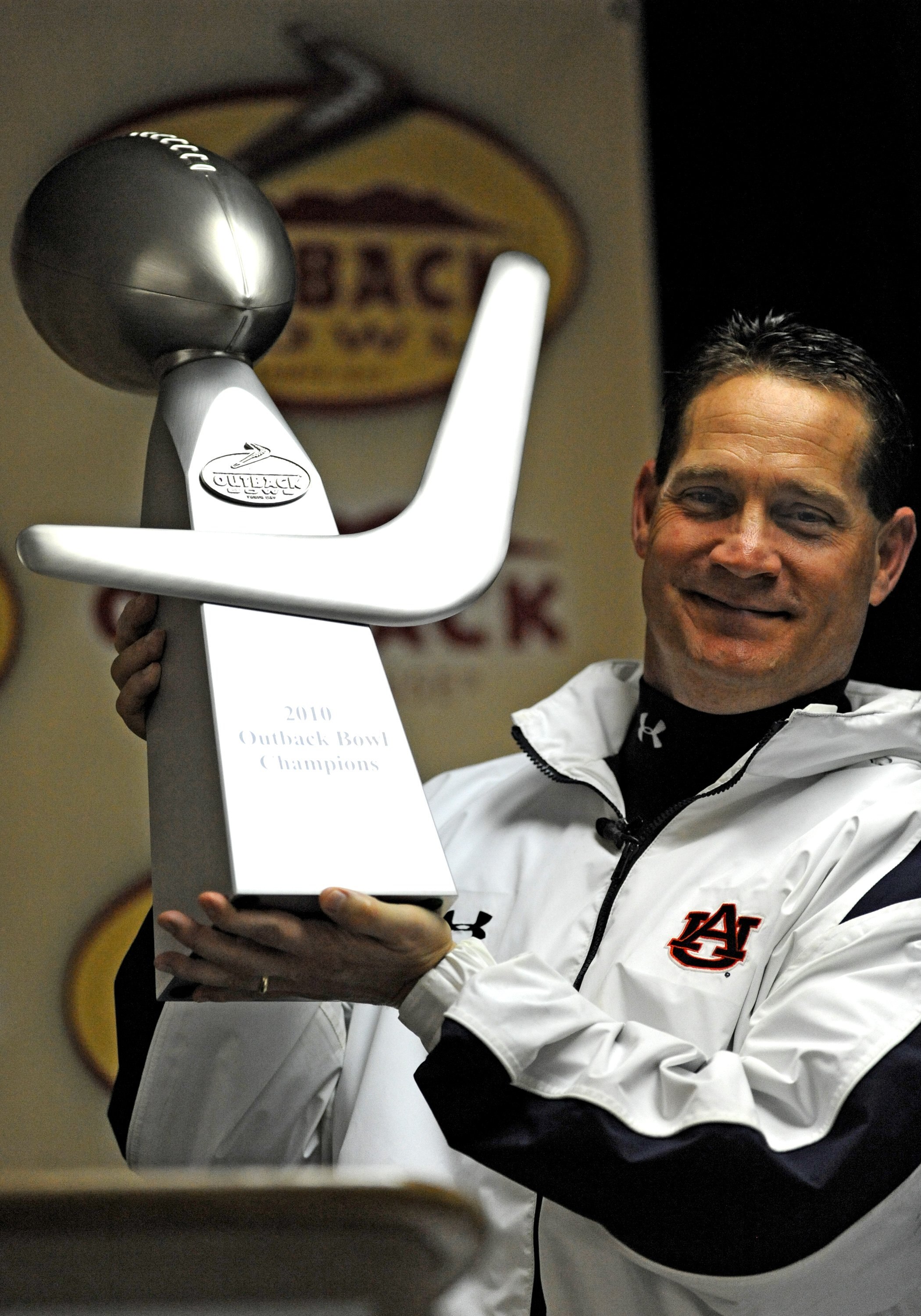 TAMPA, FL - JANUARY 1: Coach Gene Chizik of the Auburn Tigers poses with the Outback trophy after defeating the Northwestern Wildcats in the Outback Bowl January 1, 2010 at Raymond James Stadium in Tampa, Florida.  (Photo by Al Messerschmidt/Getty Images)