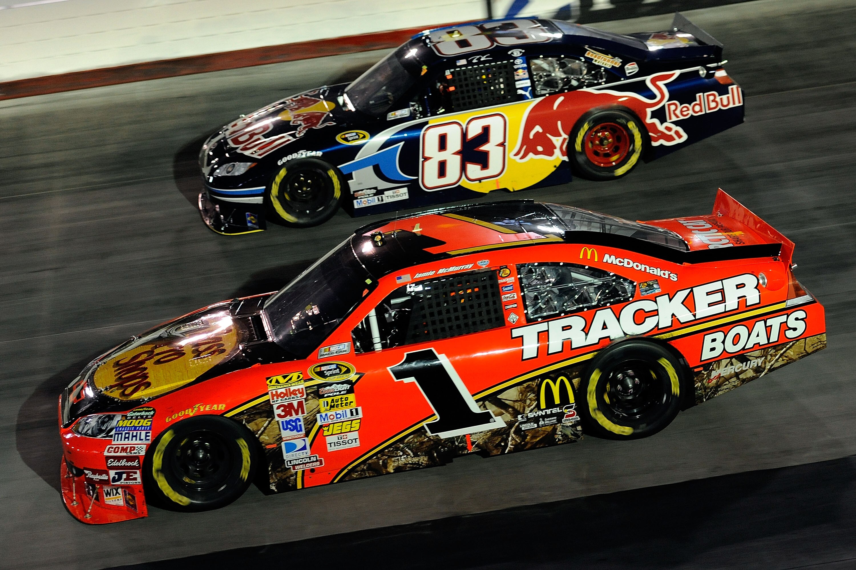 BRISTOL, TN - AUGUST 21:  Jamie McMurray, driver of the #1 Bass Pro Shops/Tracker Boats Chevrolet, and Reen Sorenson, driver of the #83 Red Bull Toyota, race side by side during the NASCAR Sprint Cup Series IRWIN Tools Night Race at Bristol Motor Speedway