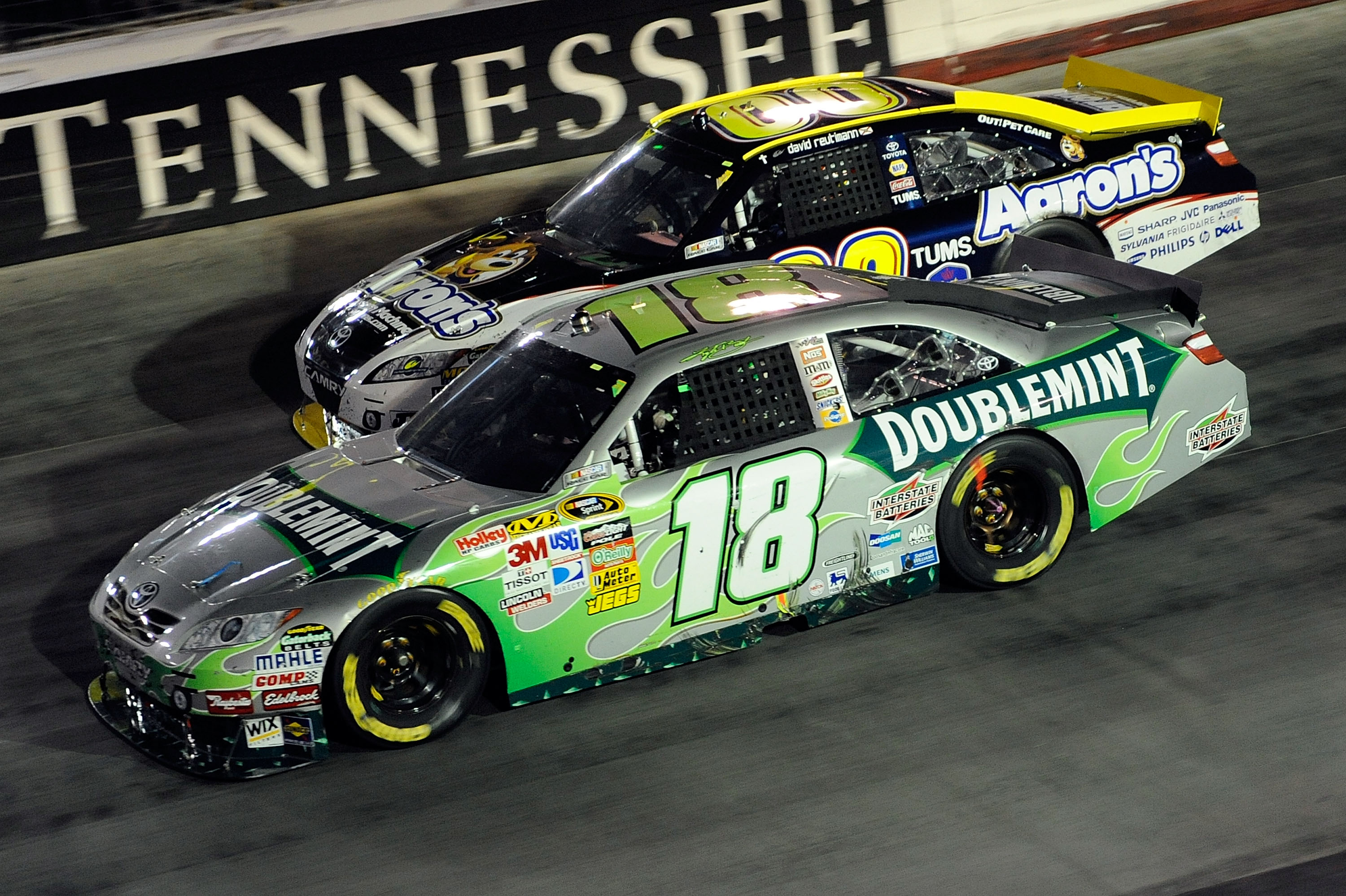 BRISTOL, TN - AUGUST 21:  Kyle Busch, driver of the #18 Doublemint Toyota, and David Reutimann, driver of the #00 Aaron's Dream Machine Toyota, race side by side during the NASCAR Sprint Cup Series IRWIN Tools Night Race at Bristol Motor Speedway on Augus
