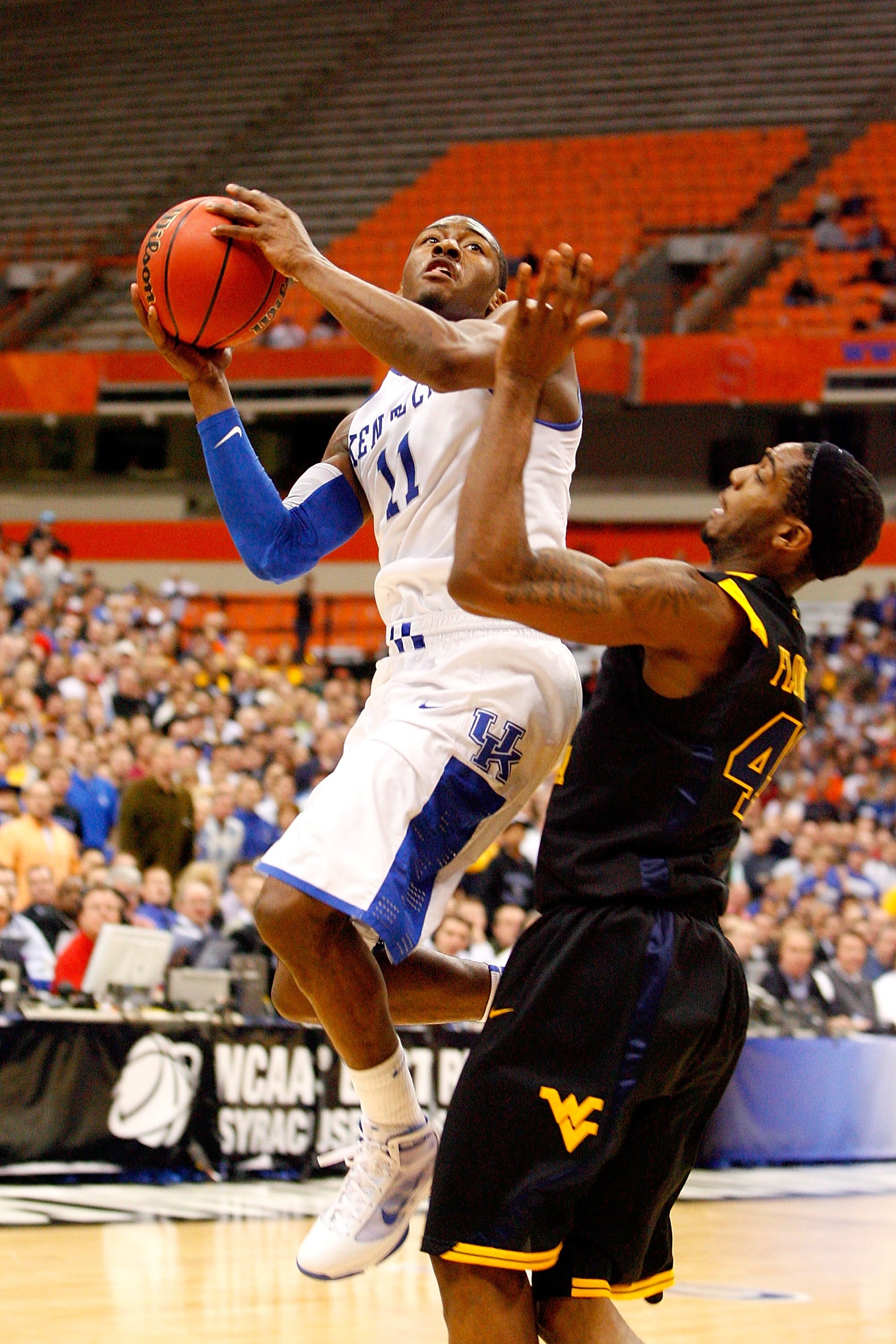 SYRACUSE, NY - MARCH 27:  John Wall #11 of the Kentucky Wildcats drives for a shot attempt against Joh Flowers #41 of the West Virginia Mountaineers during the east regional final of the 2010 NCAA men's basketball tournament at the Carrier Dome on March 2