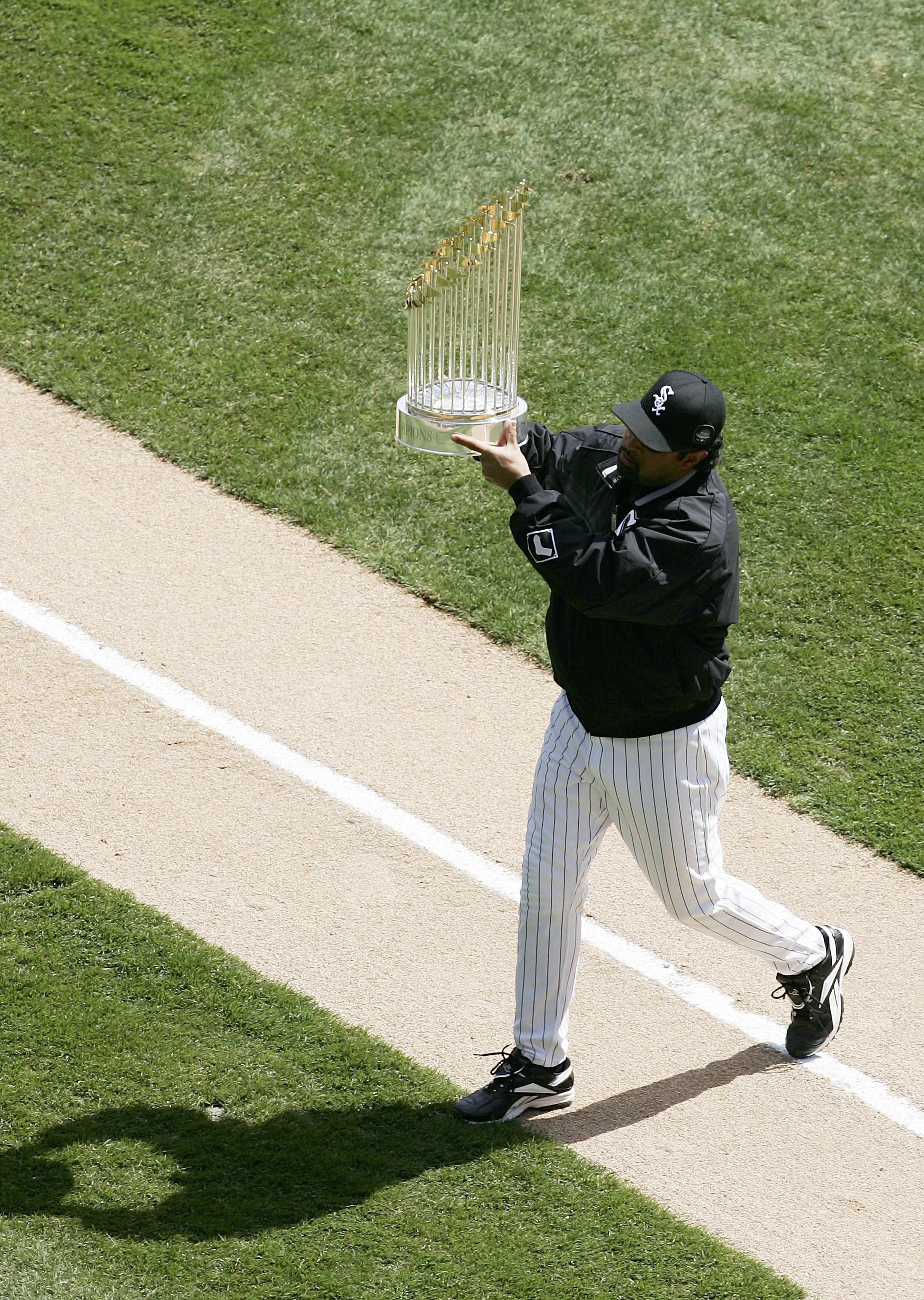 CHICAGO - APRIL 05:  Manager Ozzie Guillen of the Chicago White Sox holds the 2005 World Series Championship trophy for fans before a game against the Cleveland Indians on April 5, 2006 at U.S. Cellular Field in Chicago, Illinois. (Photo by Jonathan Danie