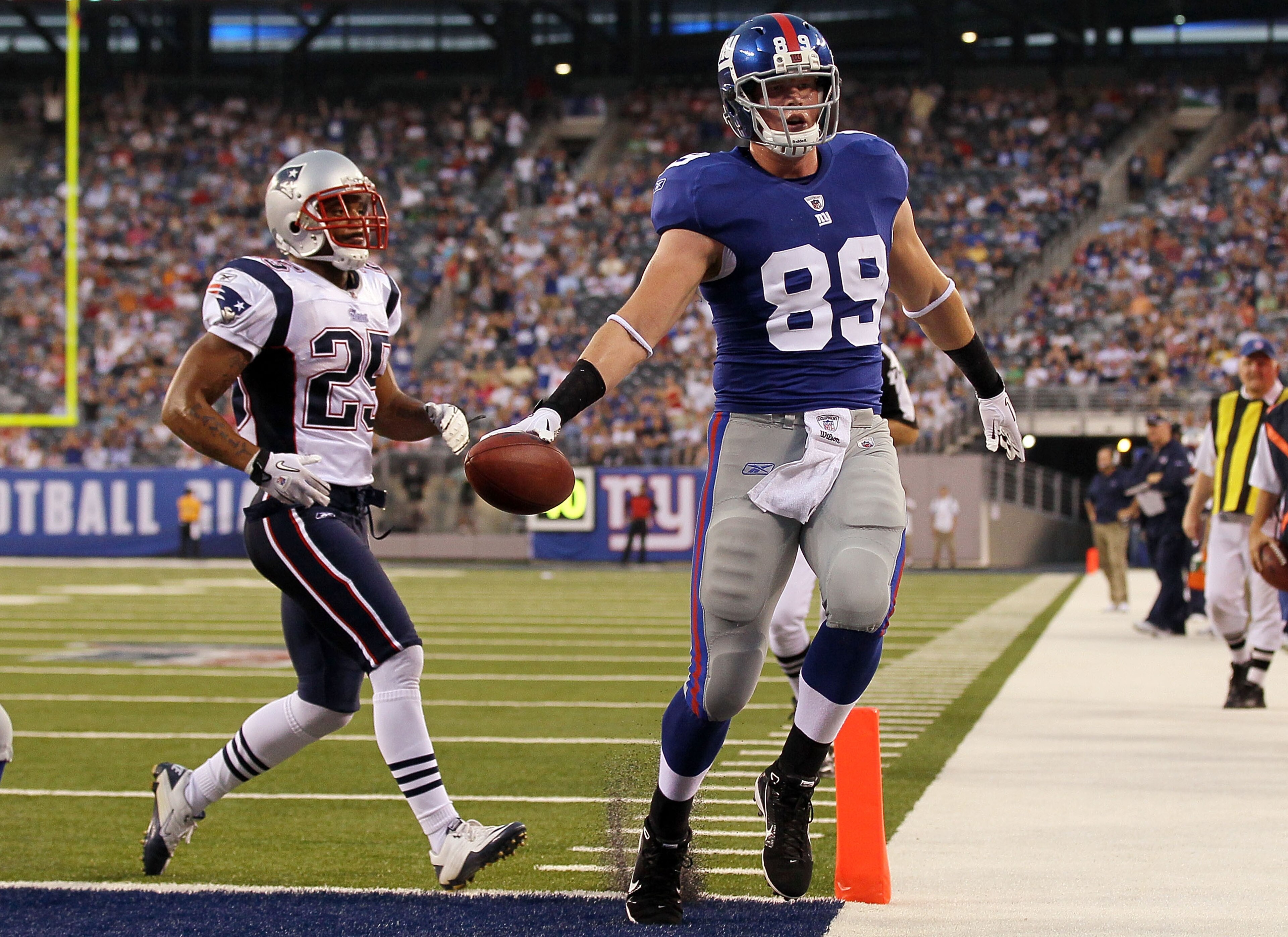 EAST RUTHERFORD, NJ - SEPTEMBER 02:  Kevin Boss #89 of the New York Giants runs in a first quarter touchdown past Patrick Chung #25 of the New England Patriots on September 2, 2010 at the New Meadowlands Stadium in East Rutherford, New Jersey.  (Photo by 