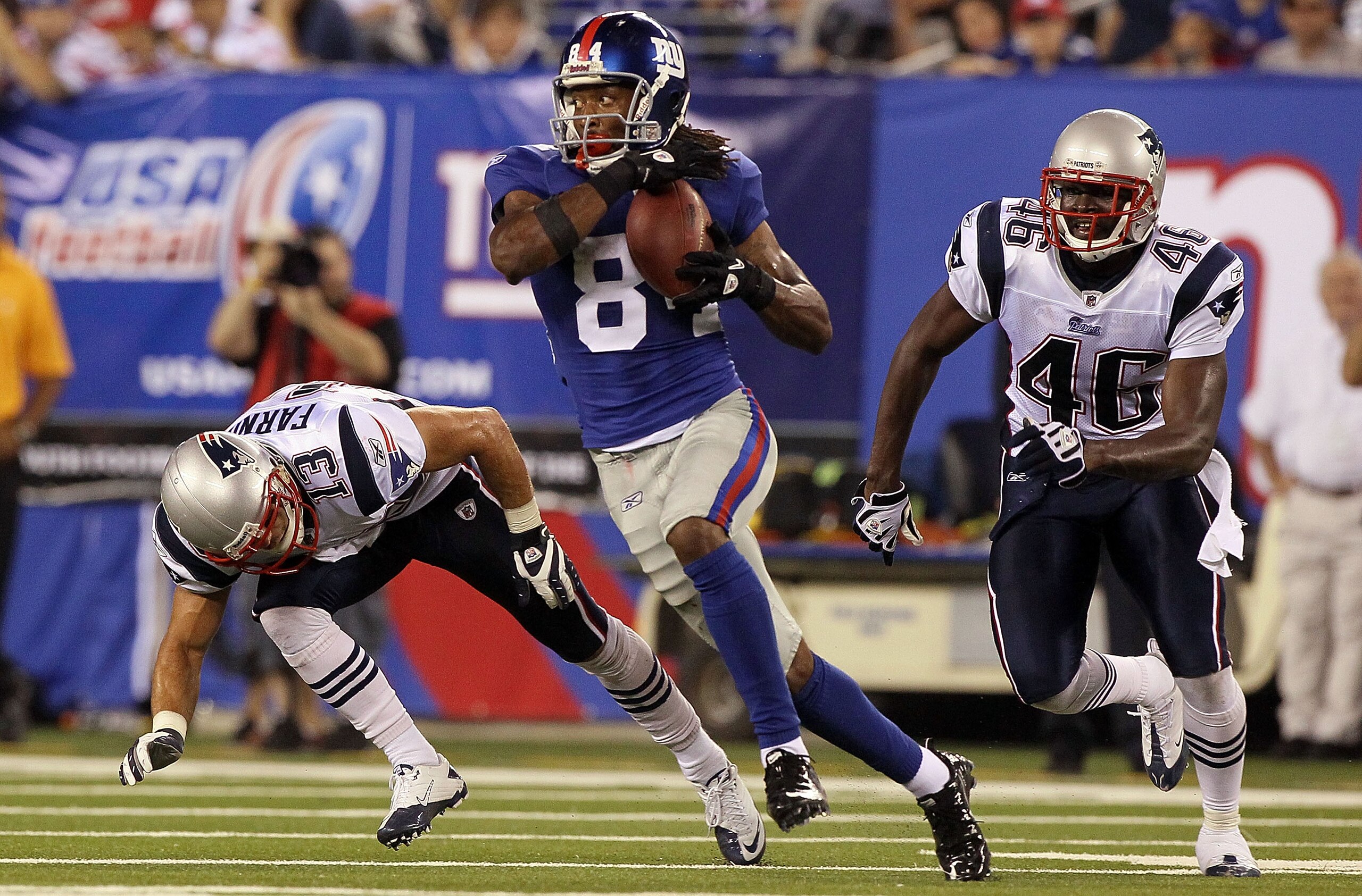 EAST RUTHERFORD, NJ - SEPTEMBER 02:  Duke Calhoun #84 of the New York Giants grabs a reception and heads for a fourth quarter touchdown past Buddy Farnham #13 and DeAngelo Willingham #46 of the New England Patriots on September 2, 2010 at the New Meadowla