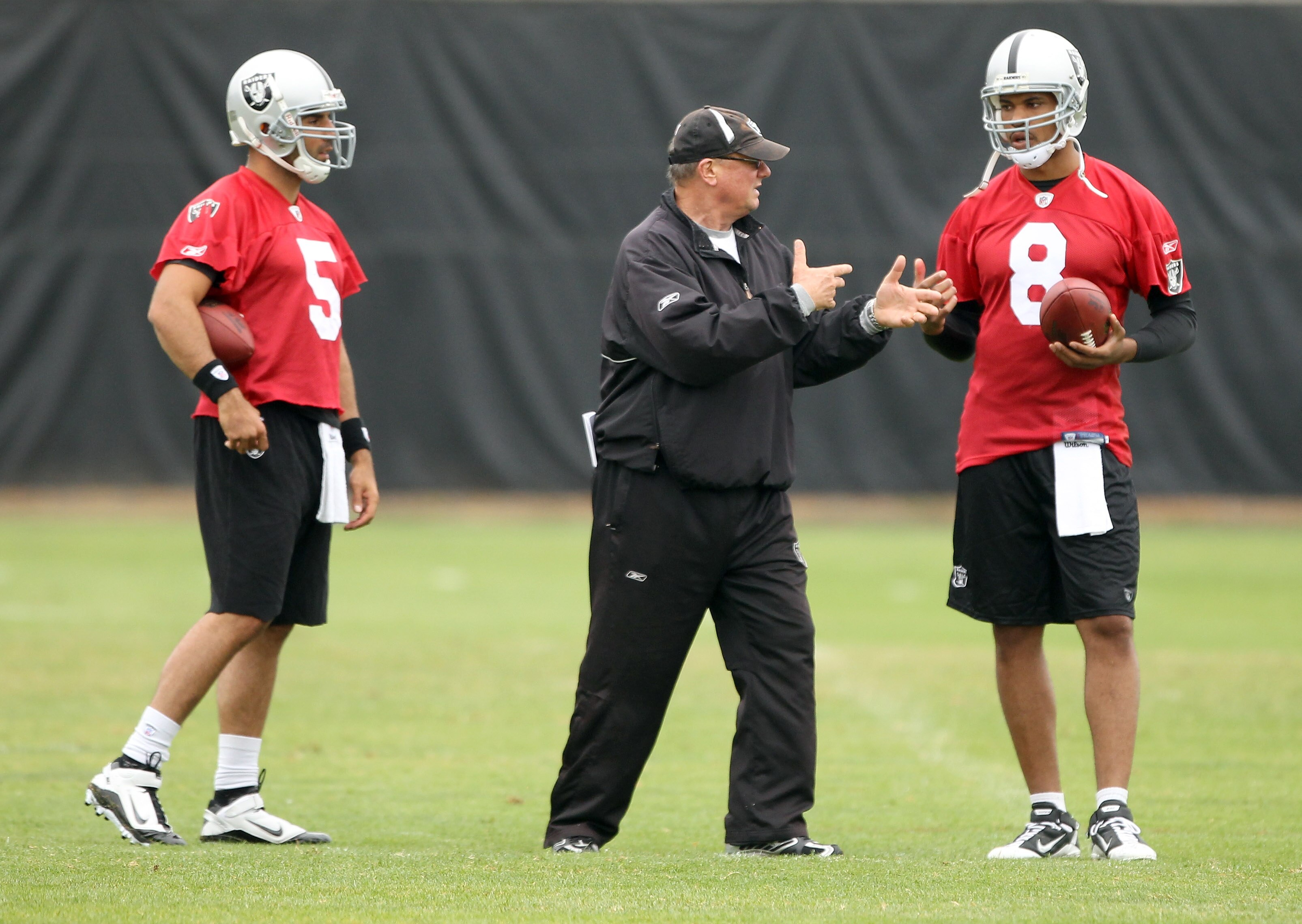 NAPA, CA - AUGUST 01:  Quarterback coach Paul Hackett speaks to Jason Campbell #8 and Bruce Gradkowski #5 of the Oakland Raiders during the Raiders training camp at their Napa Valley Training Complex on August 1, 2010 in Napa, California.  (Photo by Ezra