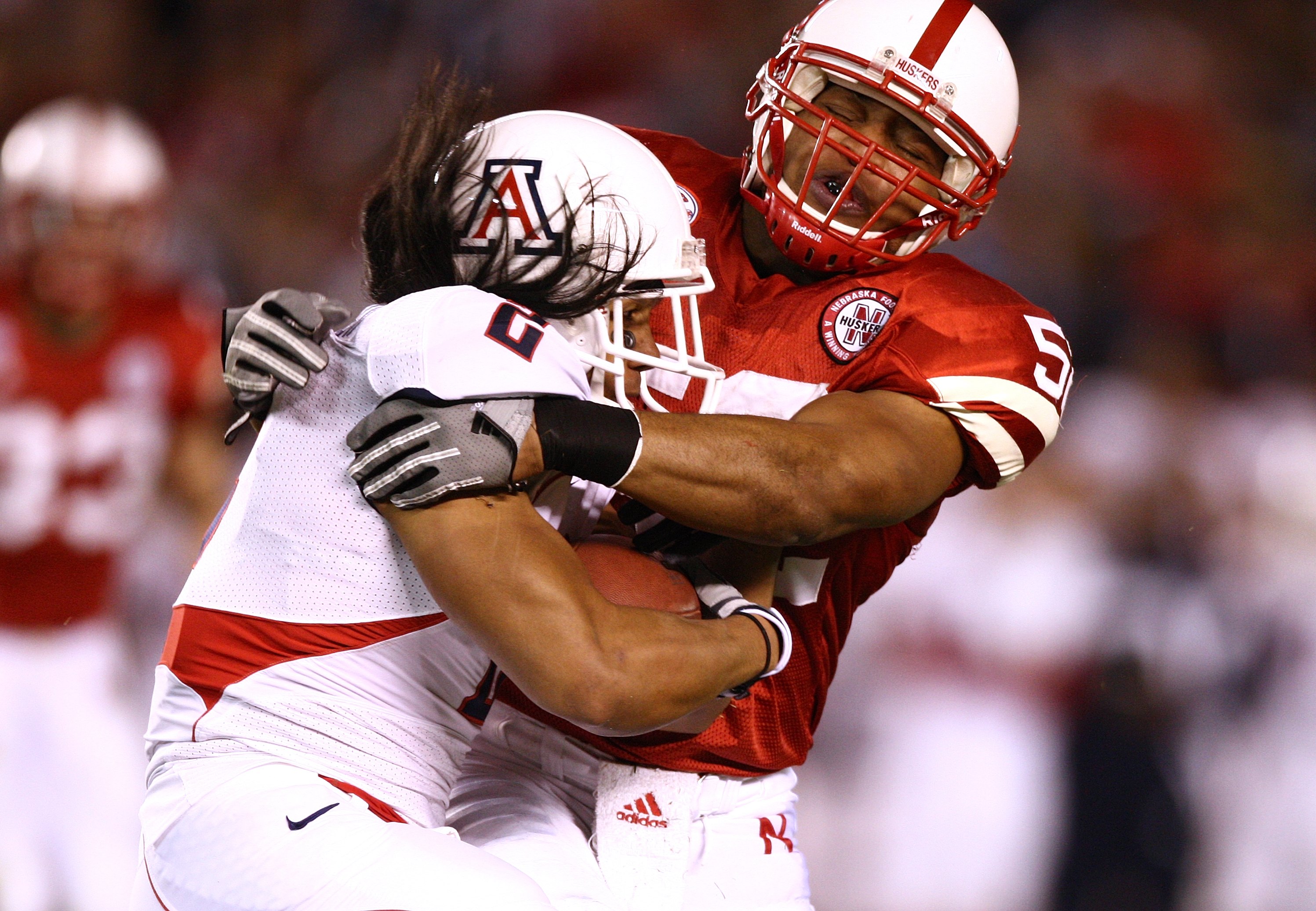 SAN DIEGO - DECEMBER 30:  Phillip Dillard #52 of the University of Nebraska Cornhuskers tackles Keola Antolin #4 of the University of Arizona Wildcats during the Pacific Life Holiday Bowl on December 30, 2009 at Qualcomm Stadium in San Diego, California.