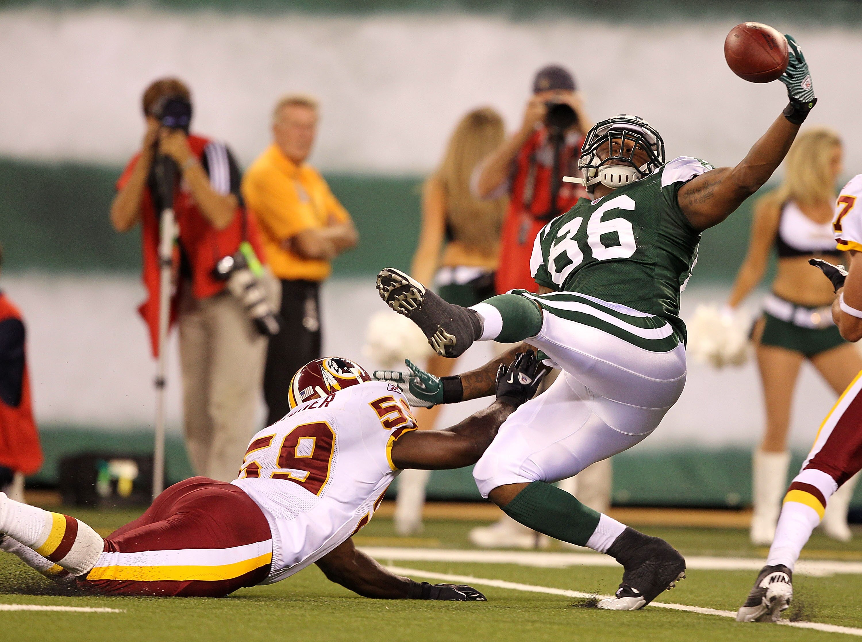 EAST RUTHERFORD, NJ - AUGUST 27:  Jeff Cumberland #86 of the New York Jets cannot hang onto the ball as London Fletcher #59 of the Washington Redskins  defends during their preseason game on August 27, 2010 at the New Meadowlands Stadium  in East Rutherfo