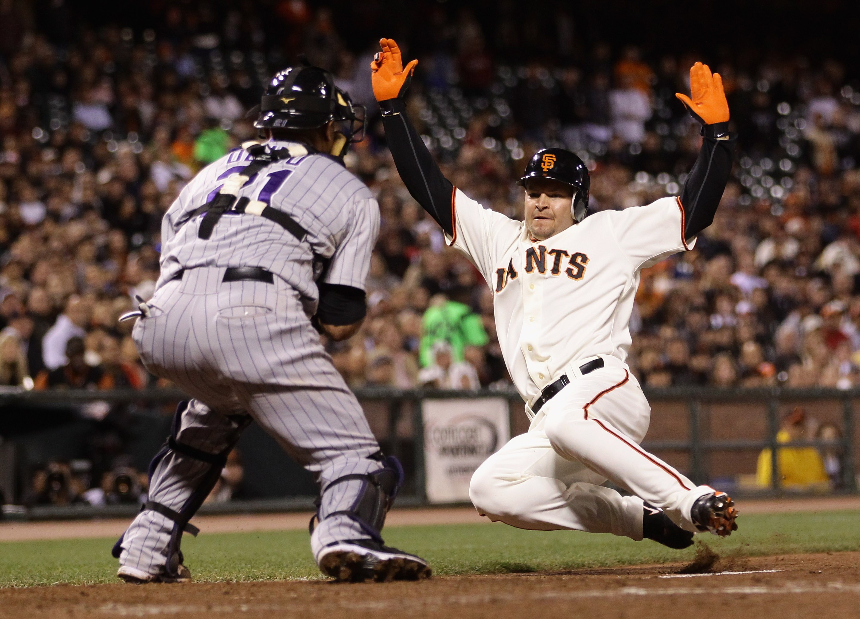 SAN FRANCISCO - AUGUST 31: Cody Ross #13 of the San Francisco Giants is tagged out by Miguel Olivo #21 the Colorado Rockies at AT&T Park on August 31, 2010 in San Francisco, California.  (Photo by Ezra Shaw/Getty Images)