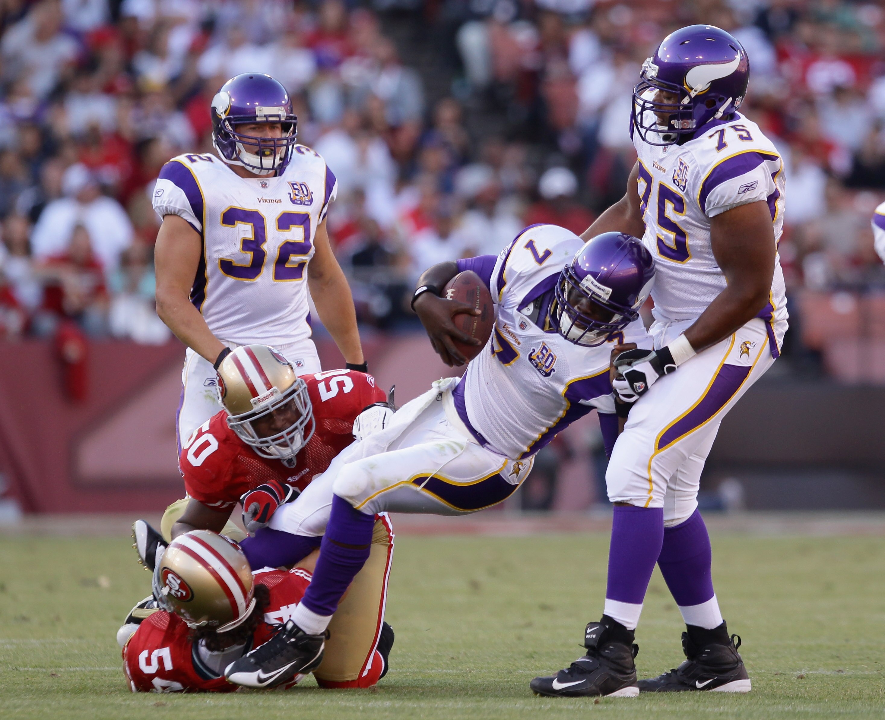 SAN FRANCISCO - AUGUST 22:  Chris Clark #75 tries to help quarterback Tarvaris Jackson #7 of the Minnesota Vikings as he is tackled by Diyral Briggs #50 and Travis LaBoy #54 of the San Francisco 49ers during a preseason game at Candlestick Park on August 
