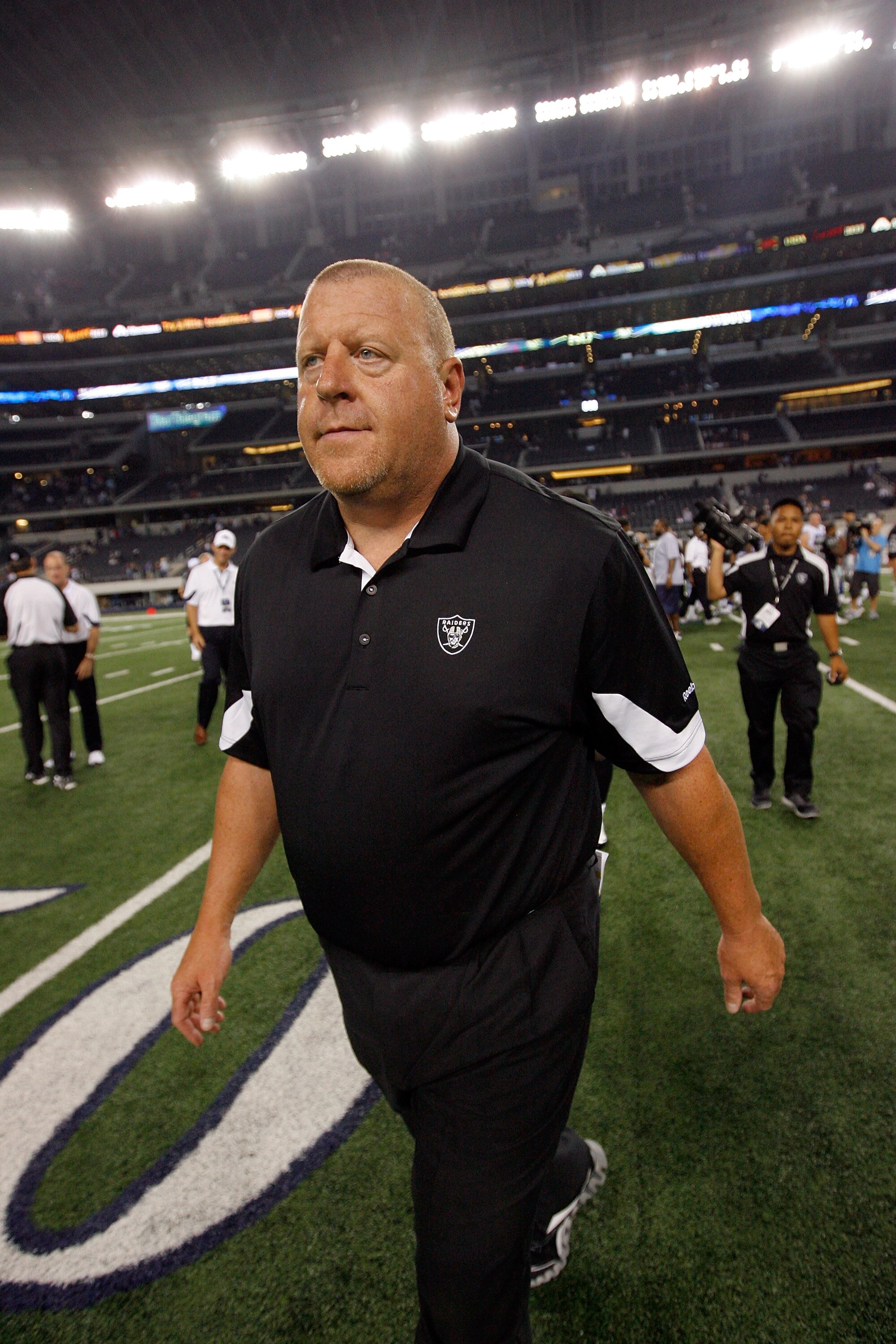 ARLINGTON, TX - AUGUST 12: Tom Cable, head coach of the Oakland Raiders, walks off the field after his team beat the Dallas Cowboys 17-9 at the Dallas Cowboys Stadium on August 12, 2010 in Arlington, Texas. (Photo by Tom Pennington/Getty Images)