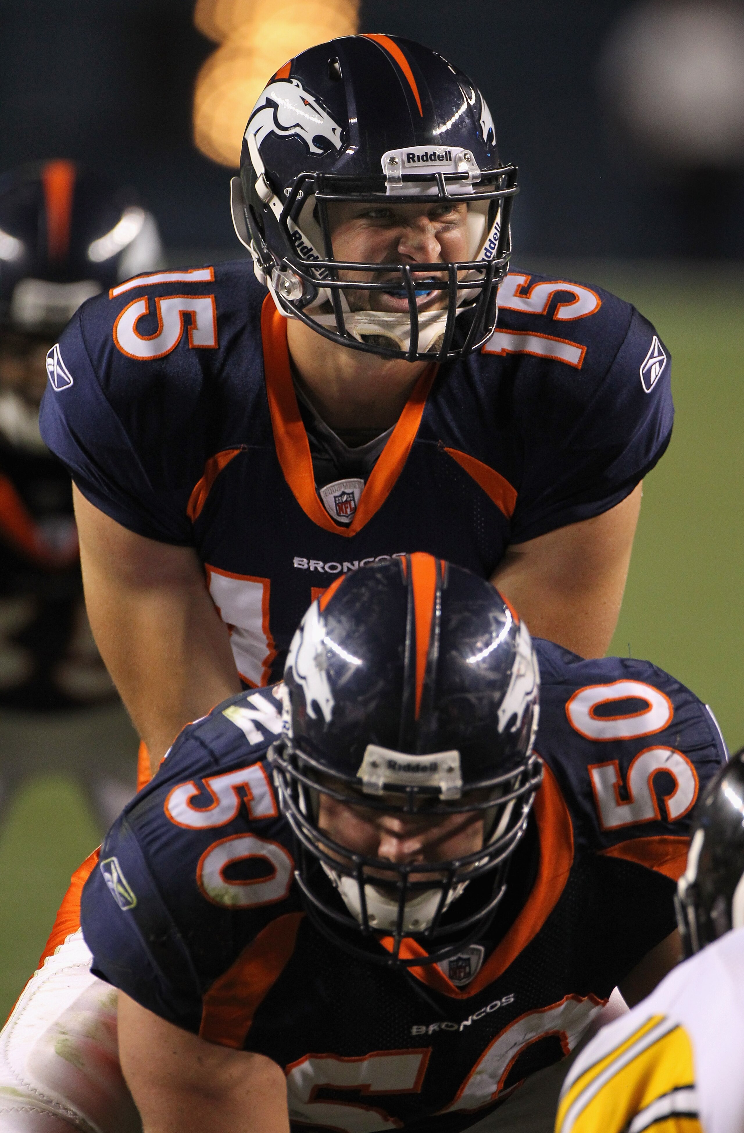 DENVER - AUGUST 29:  Quarterback Tim Tebow #15 of the Denver Broncos lines up over center J.D. Walton #50 and prepares to take the snap against the Pittsburgh Steelers during preseason NFL action at INVESCO Field at Mile High on August 29, 2010 in Denver,