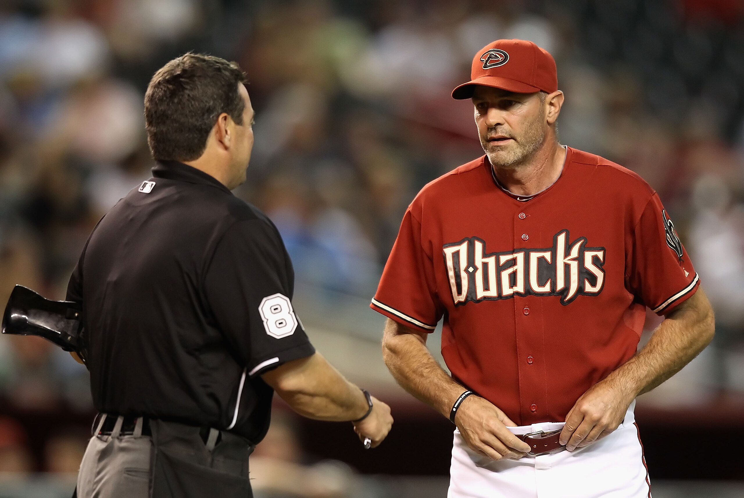 PHOENIX - AUGUST 04:  Manager Kirk Gibson of the Arizona Diamondbacks talks with home plate umpire Rob Drake during a pitching change in the Major League Baseball game against the Washington Nationals at Chase Field on August 4, 2010 in Phoenix, Arizona.