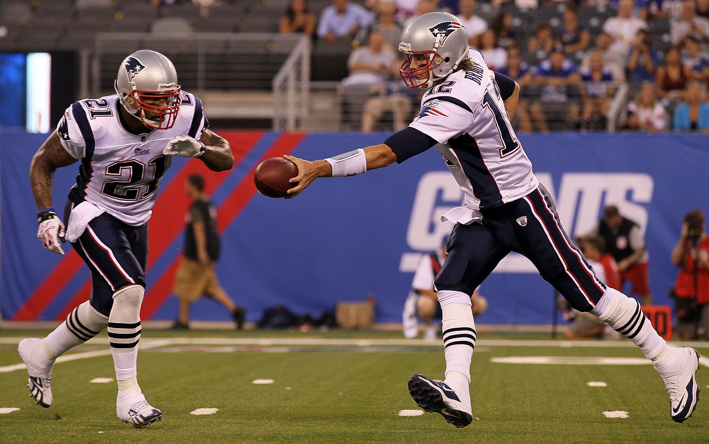 EAST RUTHERFORD, NJ - SEPTEMBER 02:  Tom Brady #12 of the New England Patriots hands off the ball against the New York Giants to teammate Fred Taylor #21 on September 2, 2010 at the New Meadowlands Stadium in East Rutherford, New Jersey.  (Photo by Jim Mc