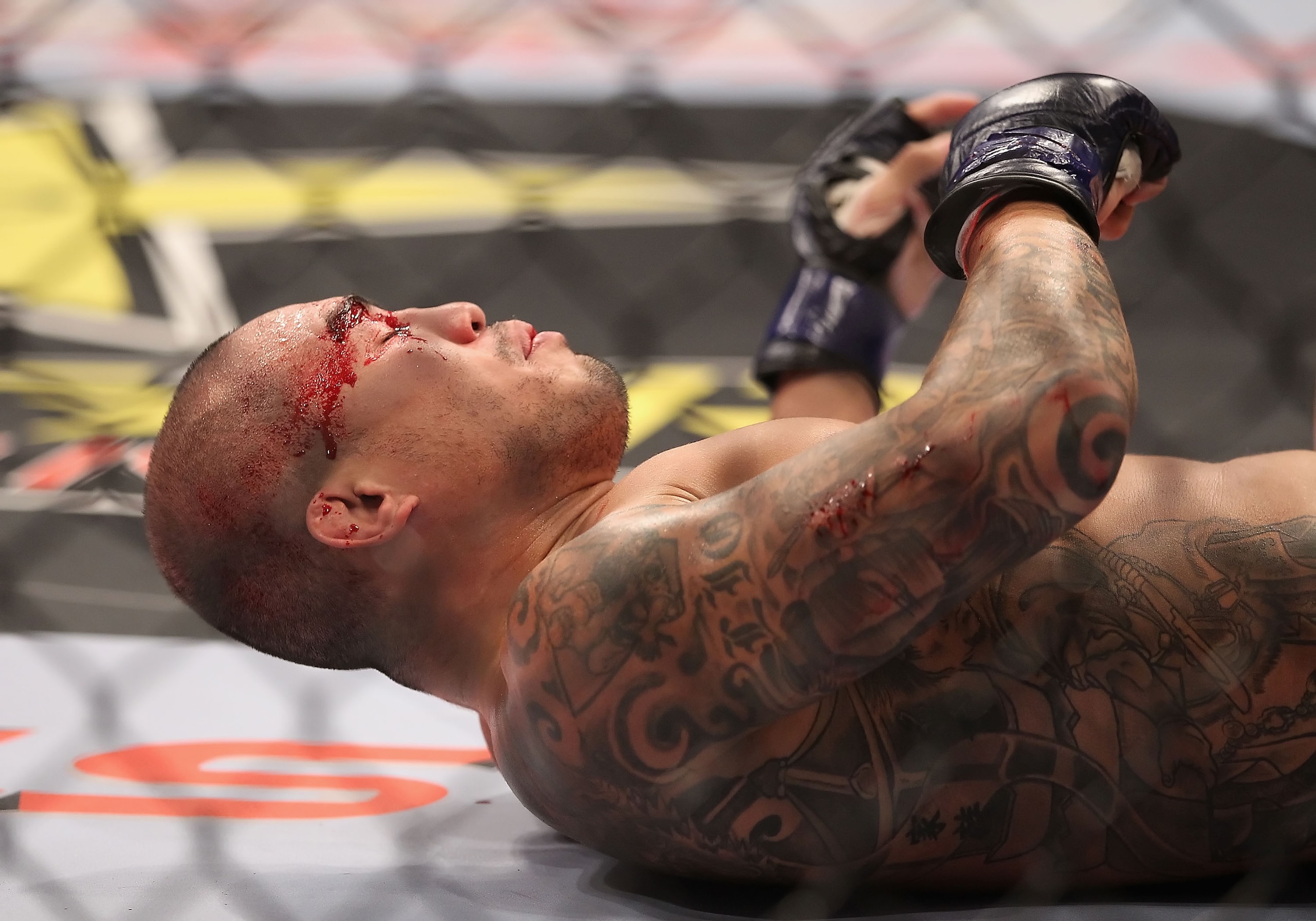 PHOENIX - AUGUST 13:  Ryan Diaz falls to the mat with a cut above his right eye during the Strikeforce Challengers Men's Undercard bout against Chris Gruetzemacher (not pictured) at Dodge Theater on August 13, 2010 in Phoenix, Arizona.  (Photo by Christia