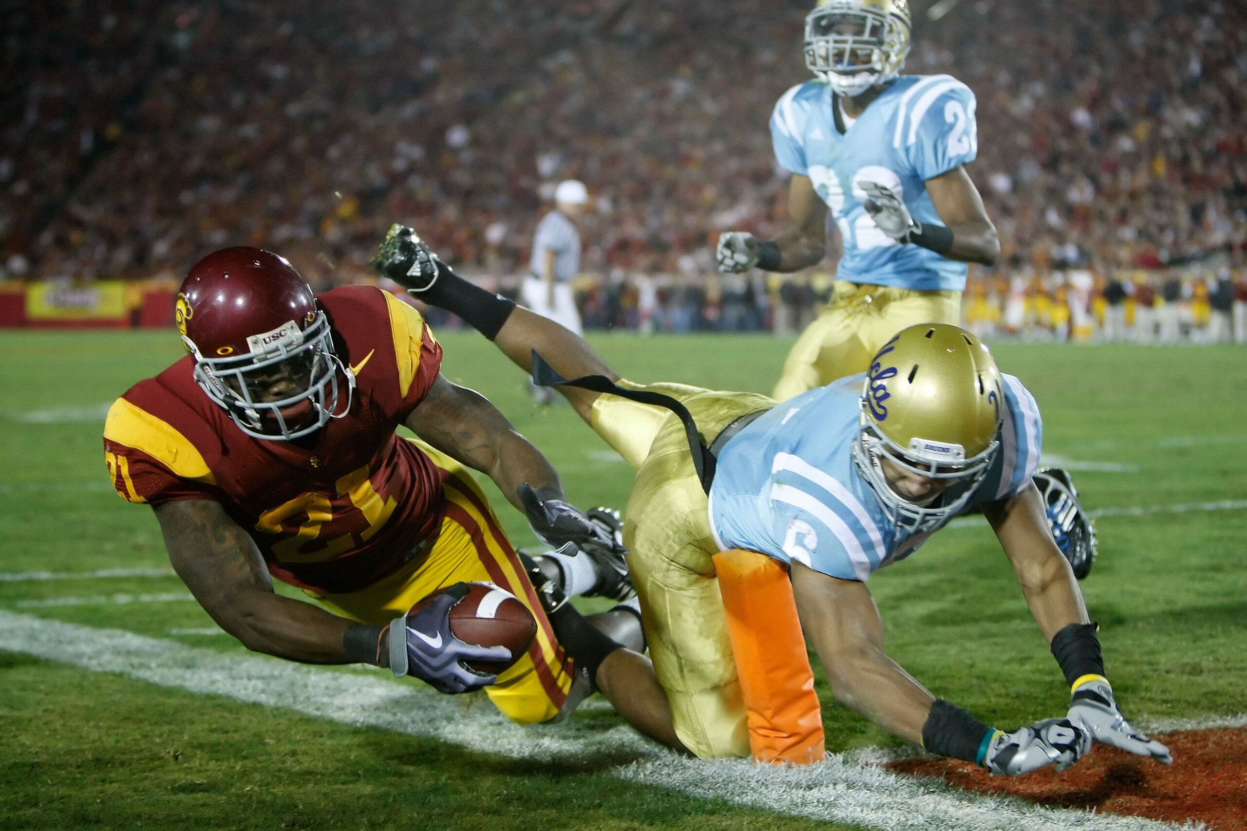 LOS ANGELES, CA - NOVEMBER 28:  Allen Bradford #21 of the USC Trojans is forced out of bounds short of the goal line by Tony Dye #6 of the UCLA Bruins in the second half at the Los Angeles Memorial Coliseum on November 28, 2009 in Los Angeles, California.