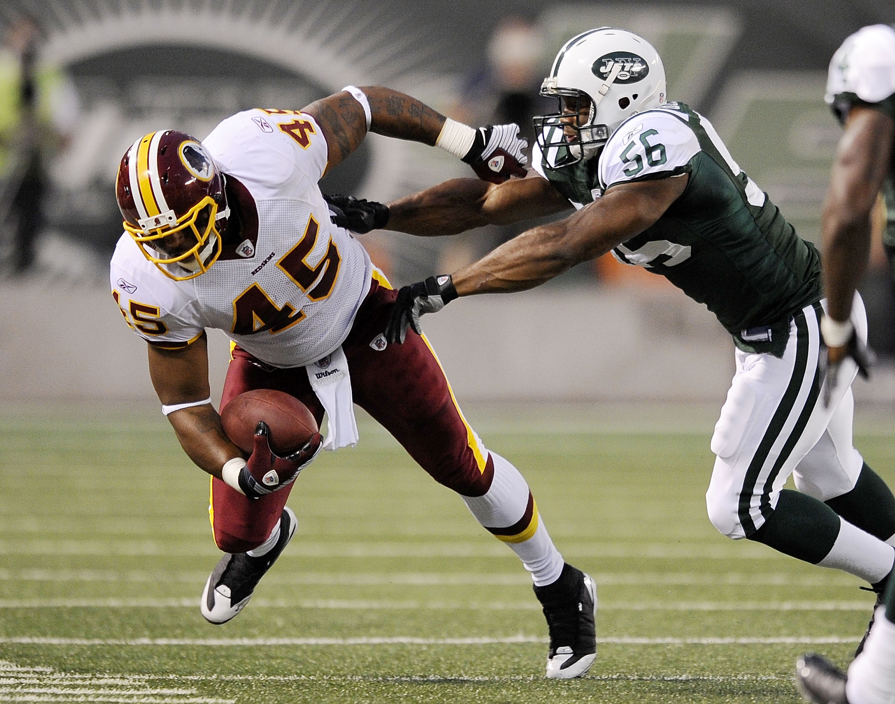 EAST RUTHERFORD, NJ - AUGUST 16:  Vernon Gholston #56 of the New York Jets  takes down Mike Sellers #45 of the Washington Redskins in a pre-season NFL game at Giants Stadium, August 16, 2008 in East Rutherford, New Jersey.  (Photo by Jeff Zelevansky/Getty