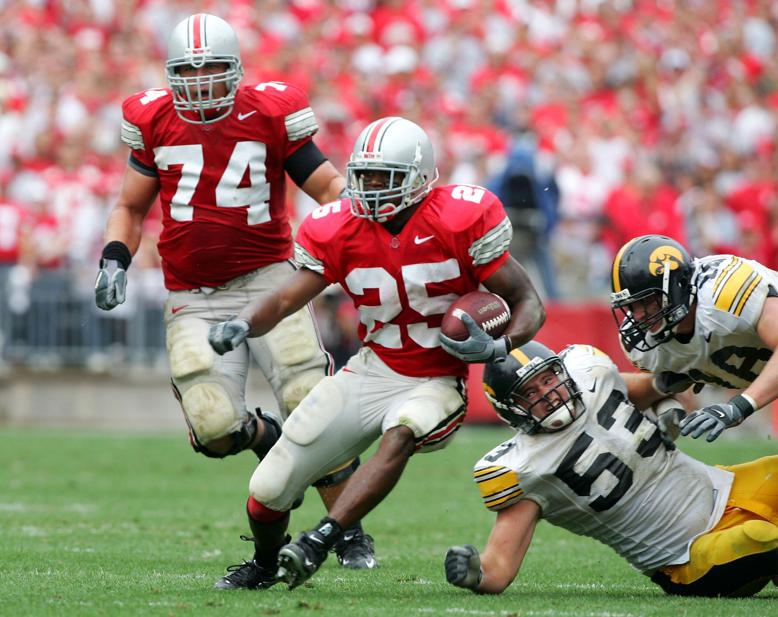 COLUMBUS, OH - SEPTEMBER 24:  Antonio Pittman #25 of Ohio State runs past a fallen Matt Kroul #53 and Chad Greenway #18 of Iowa during the third quarter on September 24, 2005 at Ohio Stadium in Columbus, Ohio. Ohio State defeated Iowa 31-6.  (Photo by Har