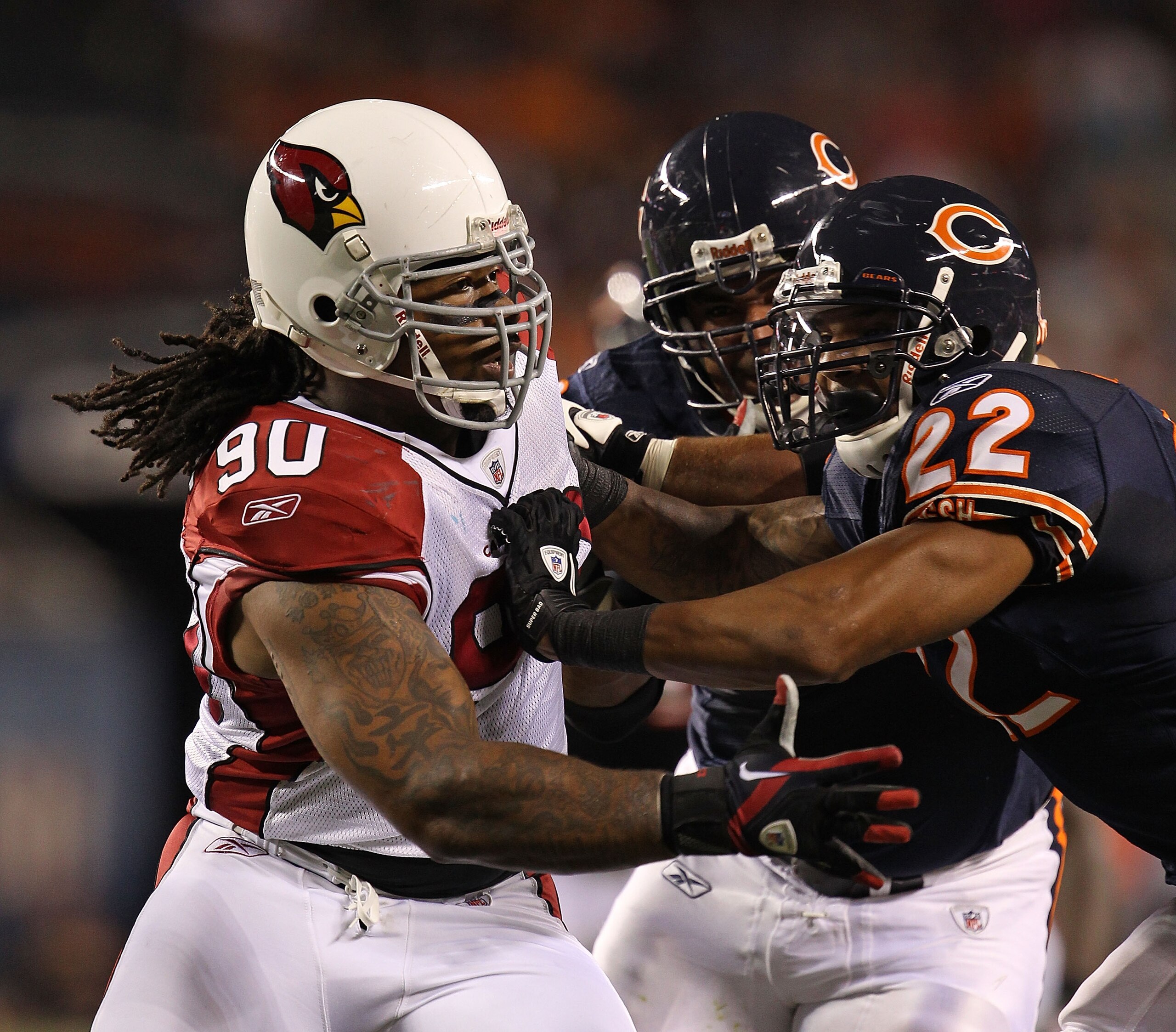 CHICAGO - AUGUST 28: Darnell Dockett #90 of the Arizona Cardinals rushes against Matt Forte #22 and Johan Asiata #62 of the Chicago Bears during a preseason game at Soldier Field on August 28, 2010 in Chicago, Illinois. The Cardinals defeated the Bears 14