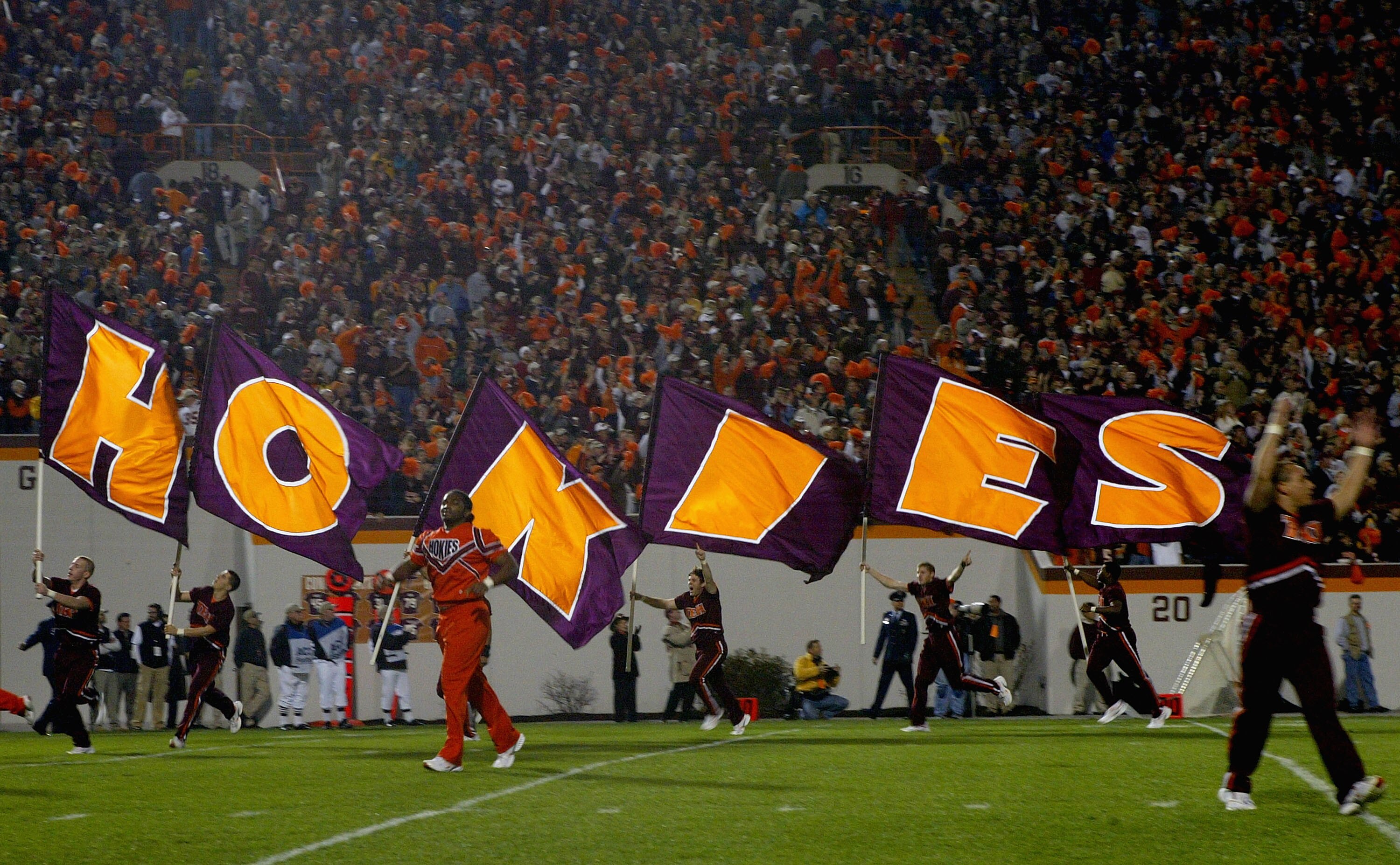 BLACKSBURG, VA - NOVEMBER 18:  Cheerleaders carry flags across as the Virginia Tech Hokies face the University of Maryland Terrapins during NCAA football at Lane Stadium November 18, 2004 in Blacksburg, Virginia.  (Photo by Doug Pensinger/Getty Images)