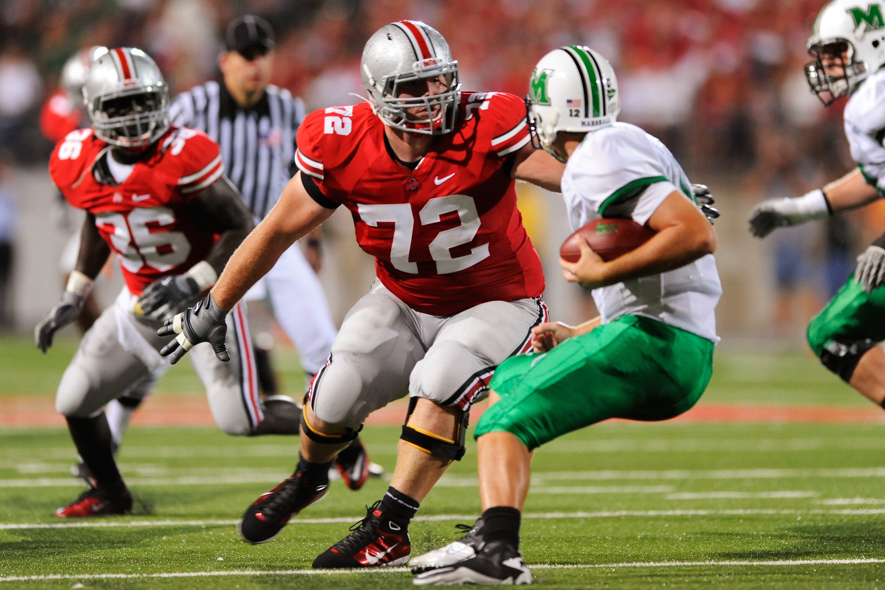 COLUMBUS, OH - SEPTEMBER 2:  Dexter Larimore #72 of the Ohio State Buckeyes corrals quarterback Brian Anderson #12 of the Marshall Thundering Herd before making the sack at Ohio Stadium on September 2, 2010 in Columbus, Ohio.  (Photo by Jamie Sabau/Getty 