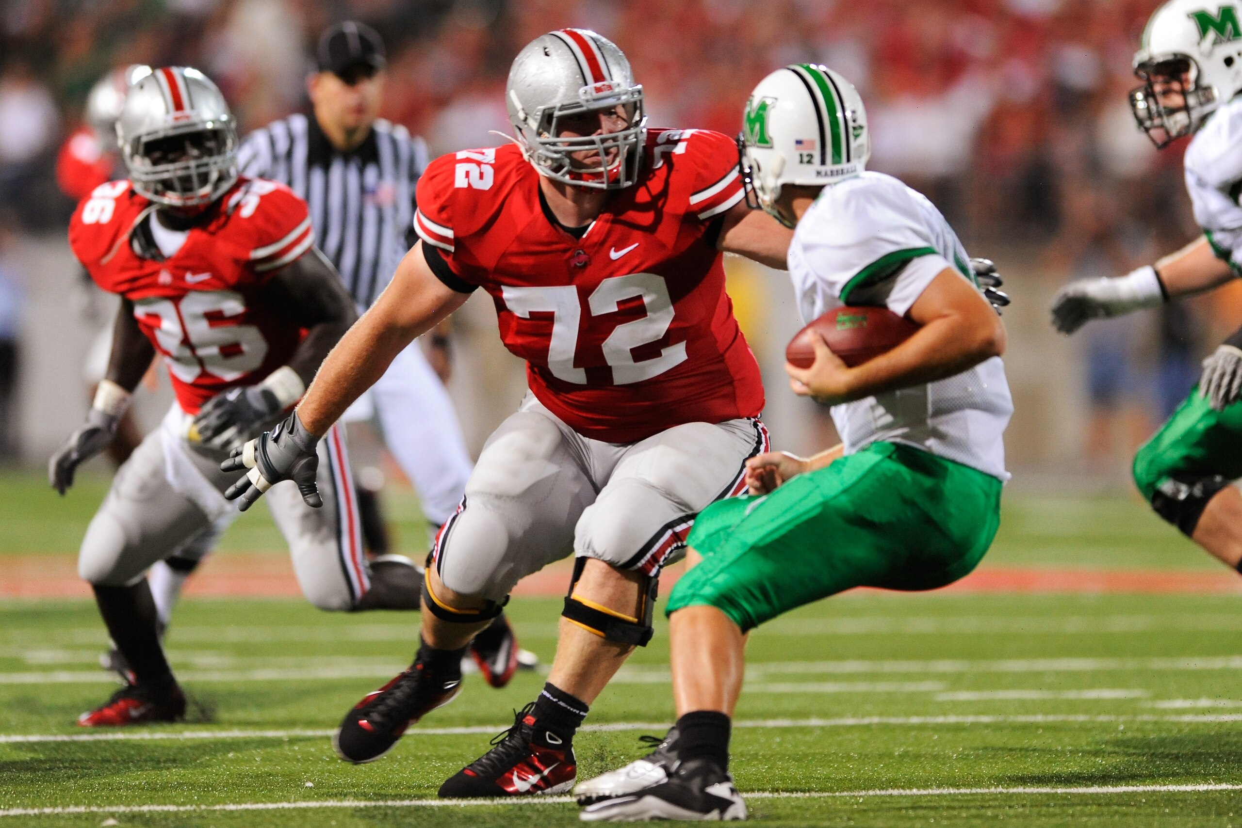 COLUMBUS, OH - SEPTEMBER 2:  Dexter Larimore #72 of the Ohio State Buckeyes corrals quarterback Brian Anderson #12 of the Marshall Thundering Herd before making the sack at Ohio Stadium on September 2, 2010 in Columbus, Ohio.  (Photo by Jamie Sabau/Getty 