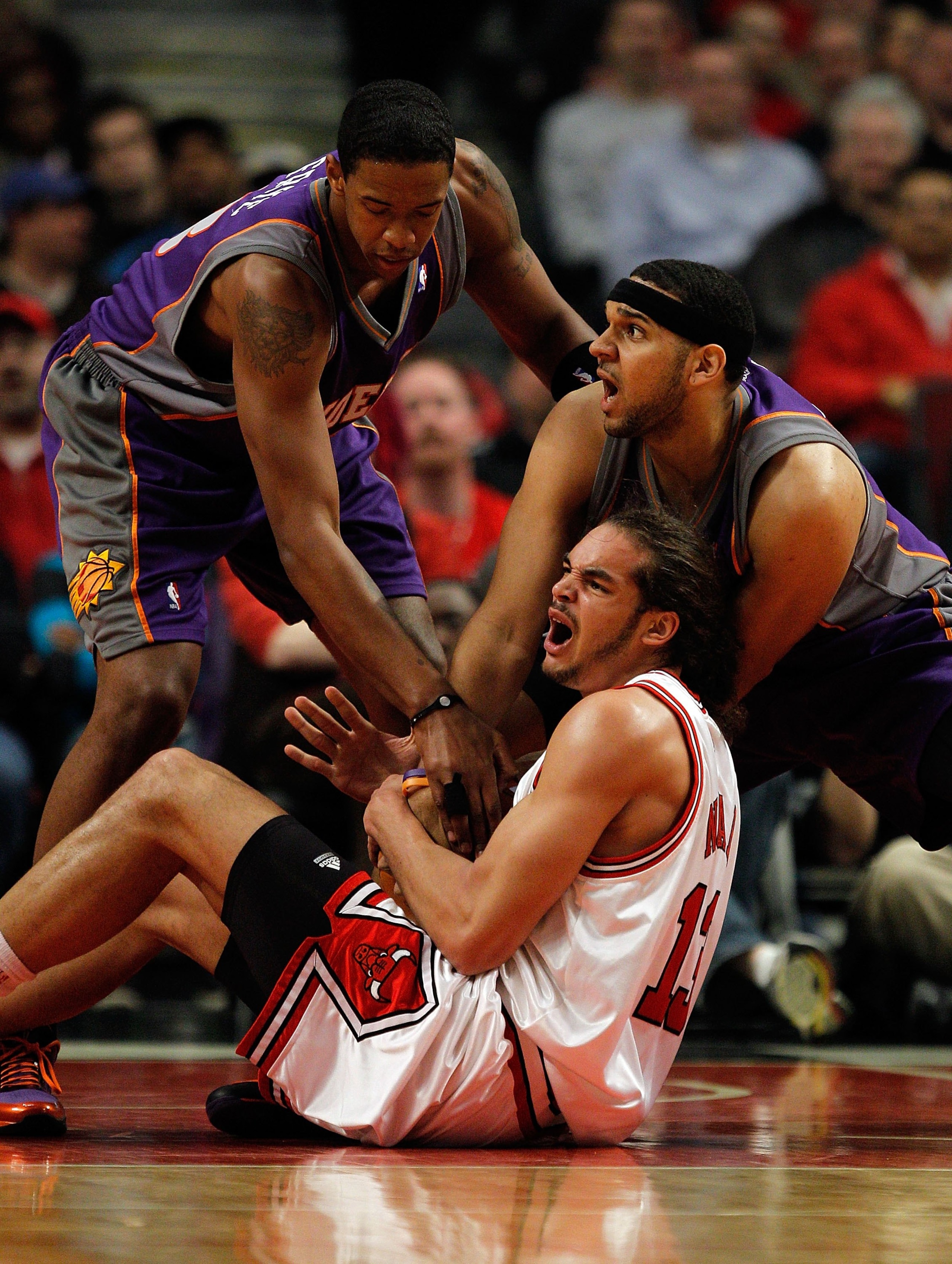 CHICAGO - MARCH 30: Joakim Noah #13 of the Chicago Bulls battles for the ball with Jared Dudley #3 and Channing Frye #8 of the Phoenix Suns at the United Center on March 30, 2010 in Chicago, Illinois. The Suns defeated the Bulls 111-105. NOTE TO USER: Use