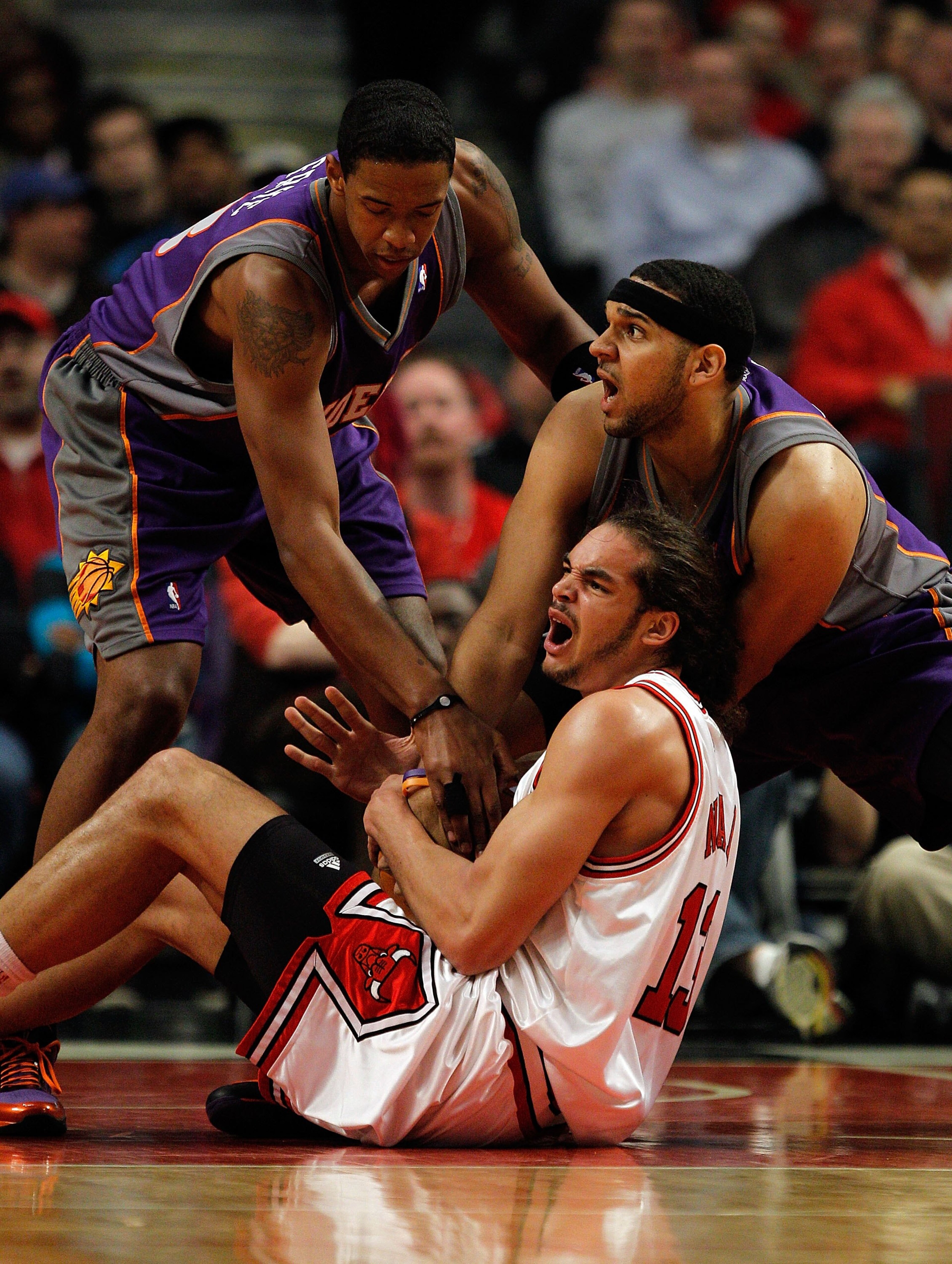 CHICAGO - MARCH 30: Joakim Noah #13 of the Chicago Bulls battles for the ball with Jared Dudley #3 and Channing Frye #8 of the Phoenix Suns at the United Center on March 30, 2010 in Chicago, Illinois. The Suns defeated the Bulls 111-105. NOTE TO USER: Use