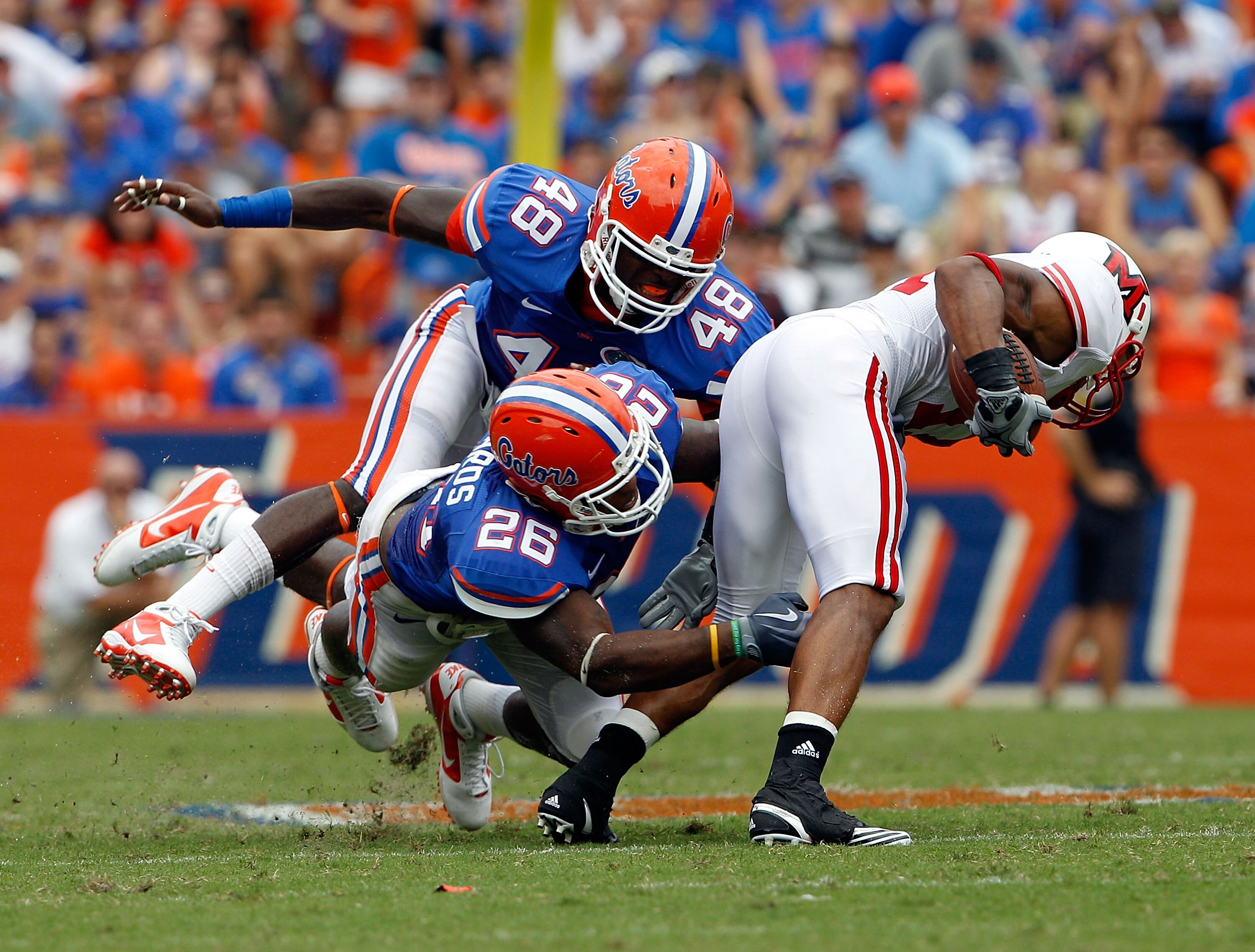 GAINESVILLE, FL - SEPTEMBER 04:  Armand Robinson #11 of the Miami University RedHawks is tackled by Neiron Ball #48 and Lorenzo Edwards #26 of the Florida Gators at Ben Hill Griffin Stadium on September 4, 2010 in Gainesville, Florida.  (Photo by Sam Gree