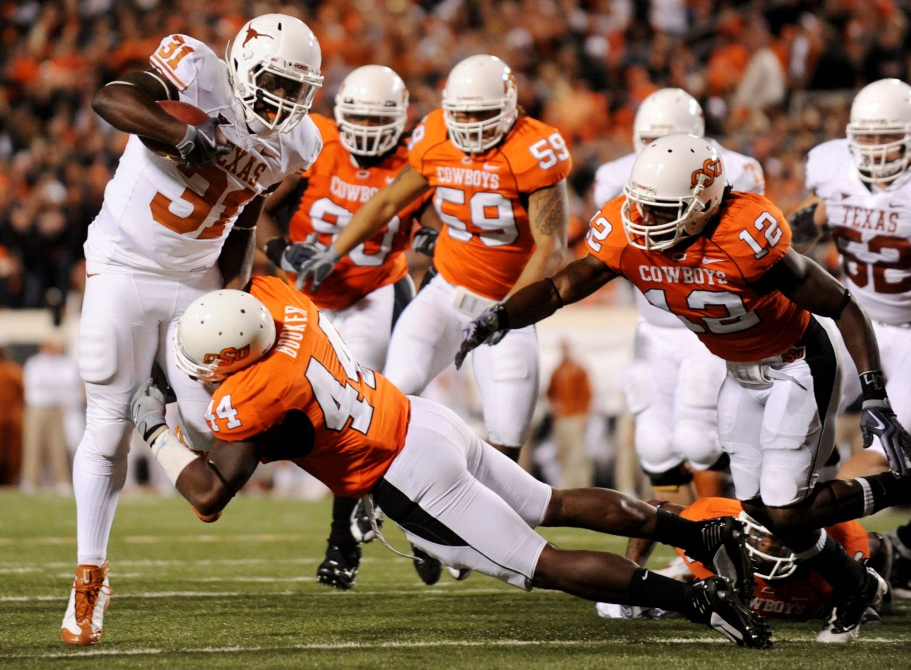 STILLWATER, OK - OCTOBER 31:  Cody Johnson #31 of the Texas Longhorns rushes for five yards short of the endzone and is stopped by Donald Booker #44 of the Oklahoma State Cowboys in the fourth quaretr of the game at Boone Pickens Stadium on October 31, 20