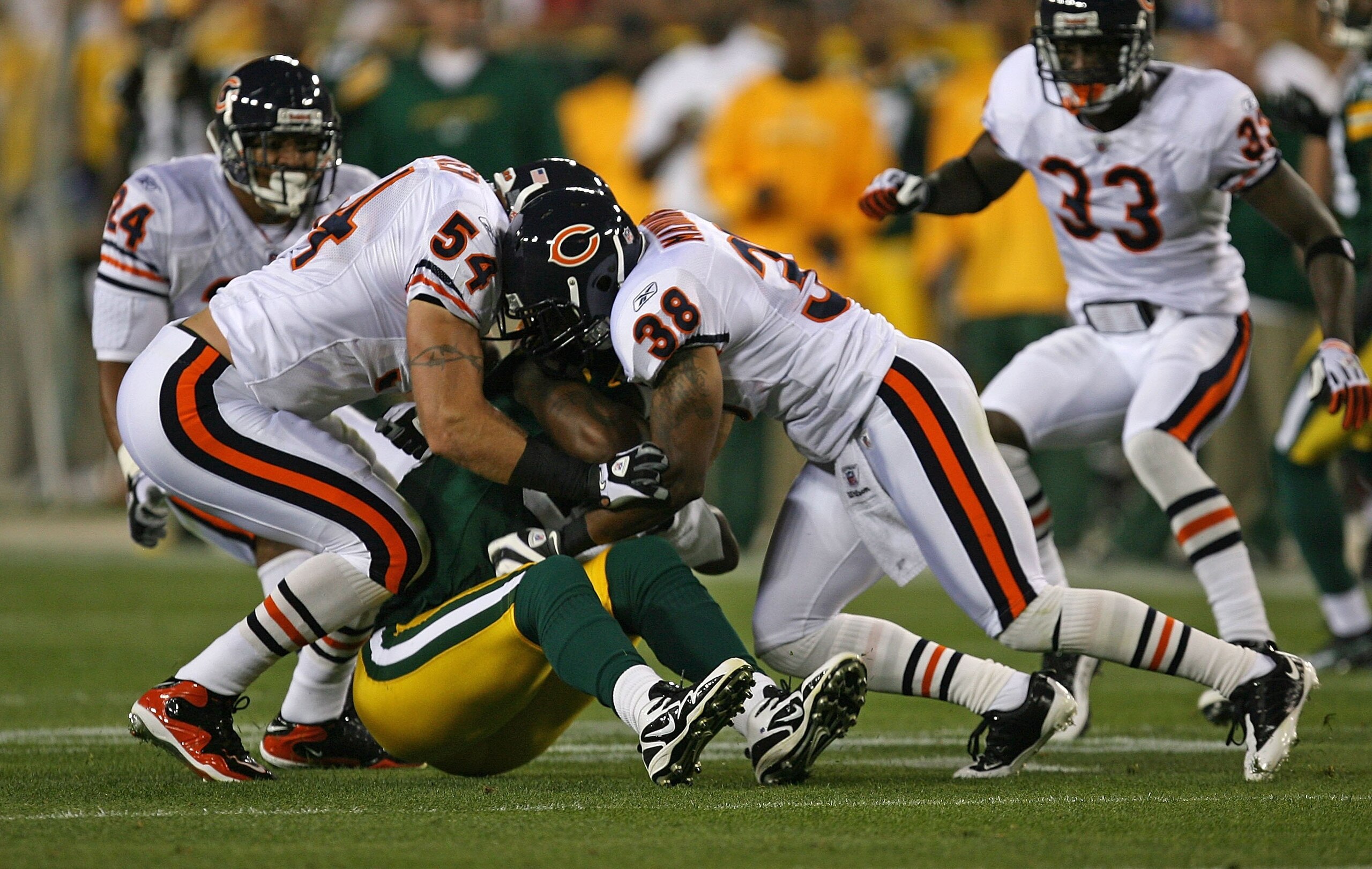 GREEN BAY, WI - SEPTEMBER 13: Brian Urlacher #54 and Danieal Manning #38 of the Chicago Bears bring down Jermichael Finley #88 of the Green Bay Packers on September 13, 2009 at Lambeau Field in Green Bay, Wisconsin. The Packers defeated the Bears 21-15. (