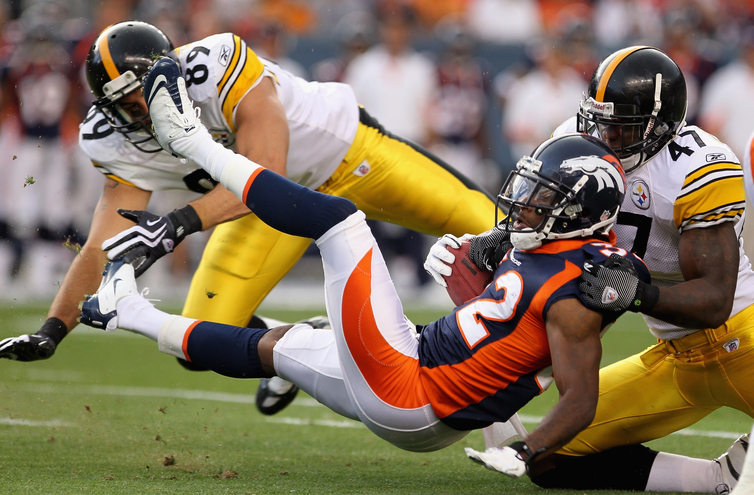 DENVER - AUGUST 29:  Cornerback Perrish Cox #32 of the Denver Broncos returns a kick off and is tackled by Stevenson Sylvester #47 and Matt Spaeth #89 of the Pittsburgh Steelers during preseason NFL action at INVESCO Field at Mile High on August 29, 2010 
