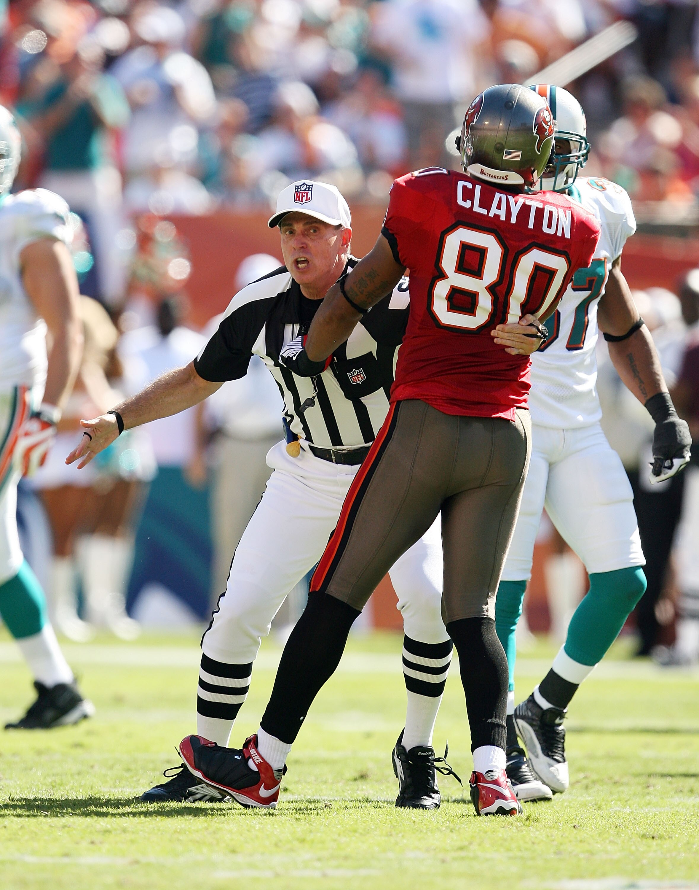 MIAMI GARDENS, FL - NOVEMBER 15:  Referee Tony Corrente #99 tries to seperate wide receiver Michael Clayton #80 of the Tampa Bay Buccaneers from getting into a fight with Dolphin players while taking on the Miami Dolphins at Land Shark Stadium on November
