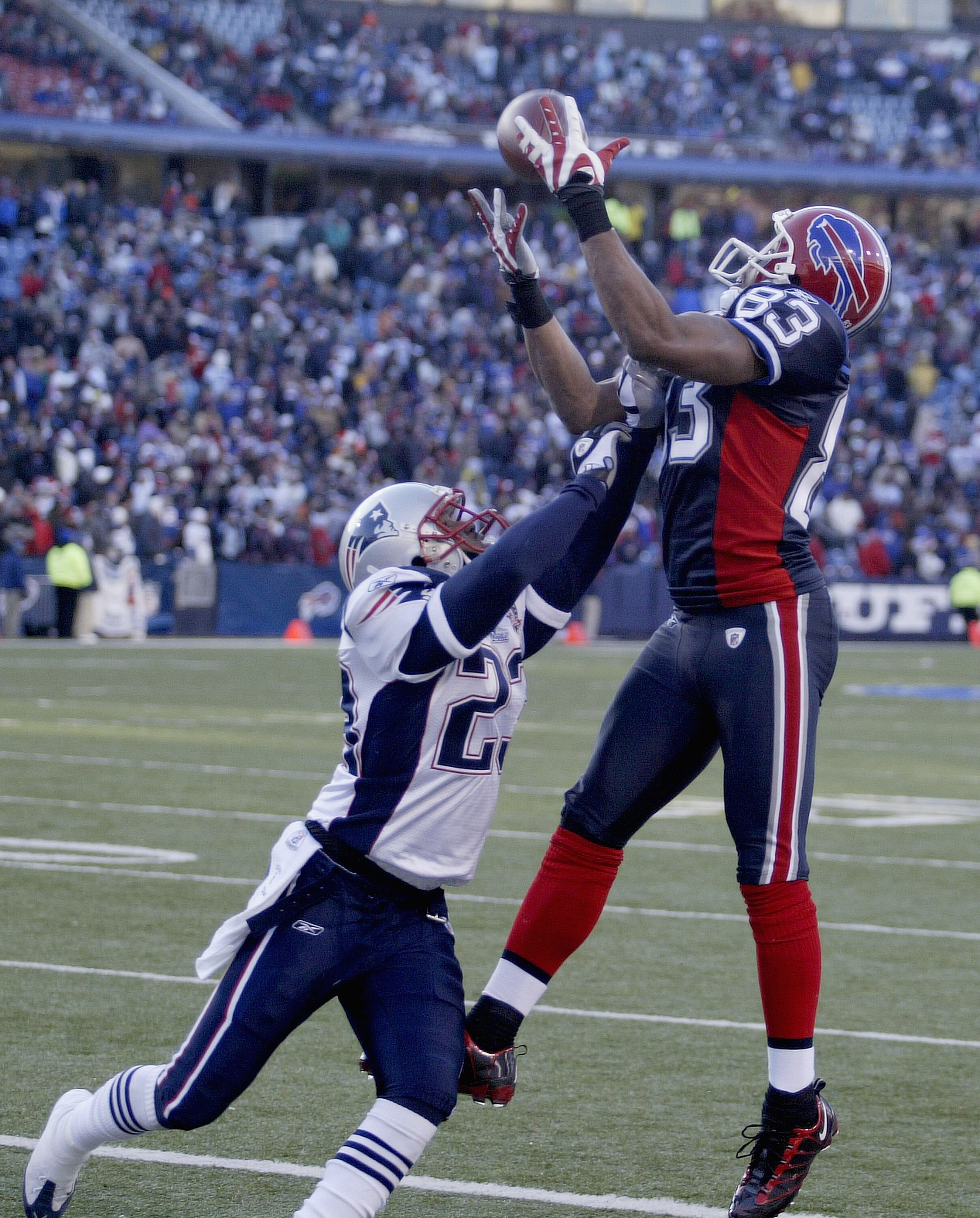 ORCHARD PARK, NY - DECEMBER 20:  Lee Evans #83  of the Buffalo Bills makes a catch as Leigh Bodden #23 of the New England Patriots defends at Ralph Wilson Stadium on December 20, 2009 in Orchard Park, New York.Evans was deemed to have come down out of bou