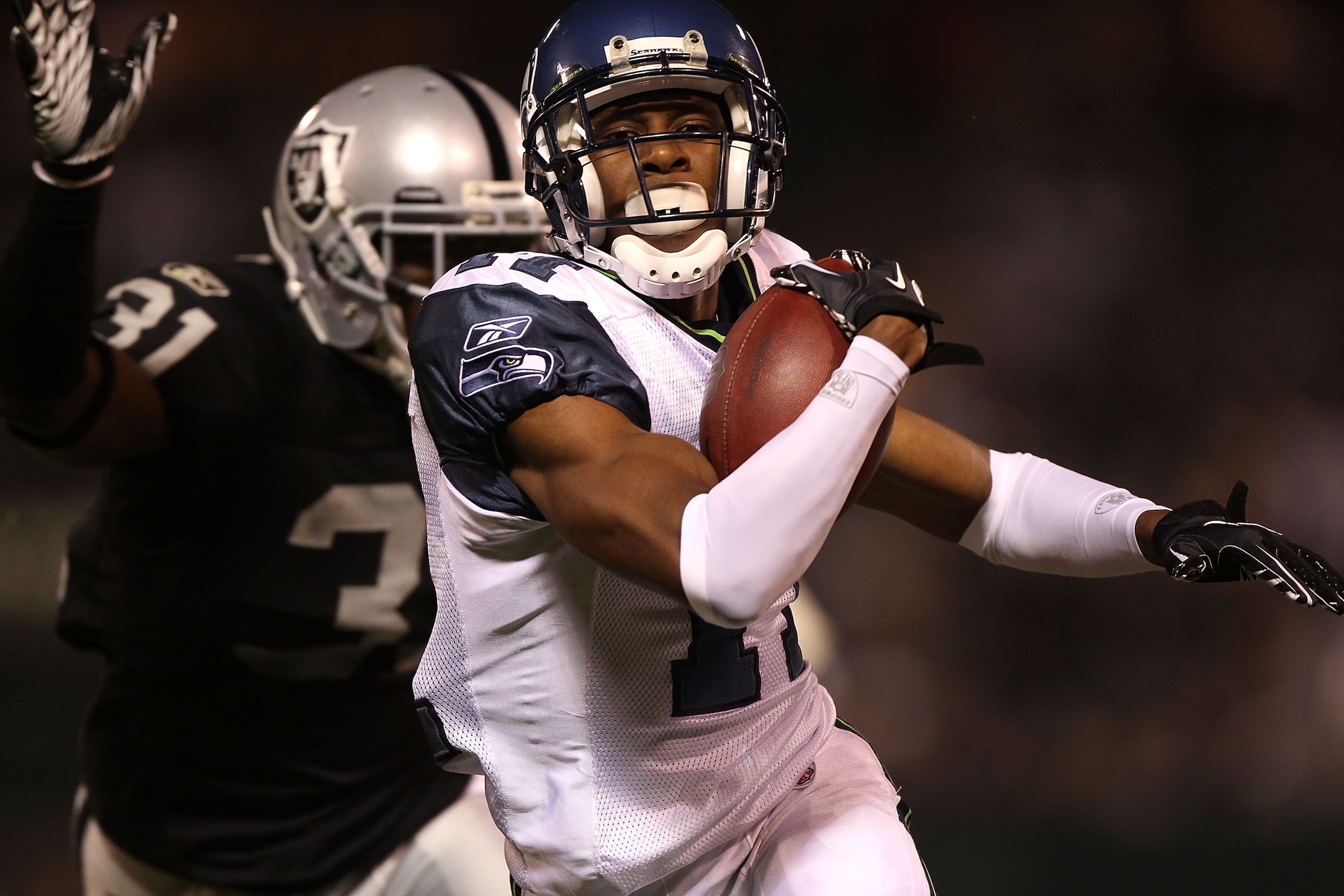OAKLAND, CA - SEPTEMBER 02:  Deon Butler #11 of the Seattle Seahawks scores a touchdown as Hiram Eugene #31 of the Oakland Raiders defends during an NFL preseason game at Oakland-Alameda County Coliseum on September 2, 2010 in Oakland, California.  (Photo