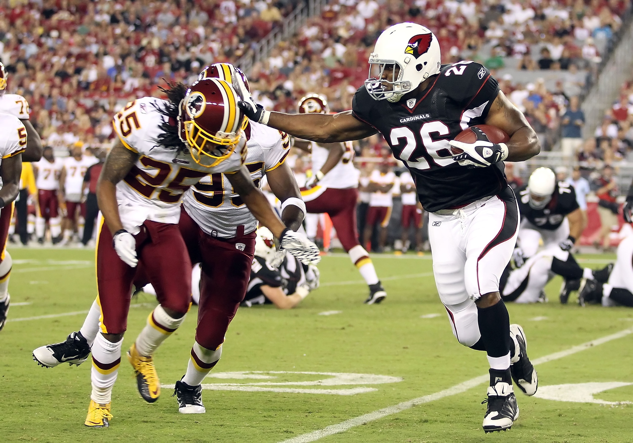 GLENDALE, AZ - SEPTEMBER 02:  Runningback Beanie Wells #26 of the Arizona Cardinals rushes the football against Chris Wilson #95 and Kevin Barnes #25 of the Washington Redskins during the first quarter of the preseason NFL game at the University of Phoeni