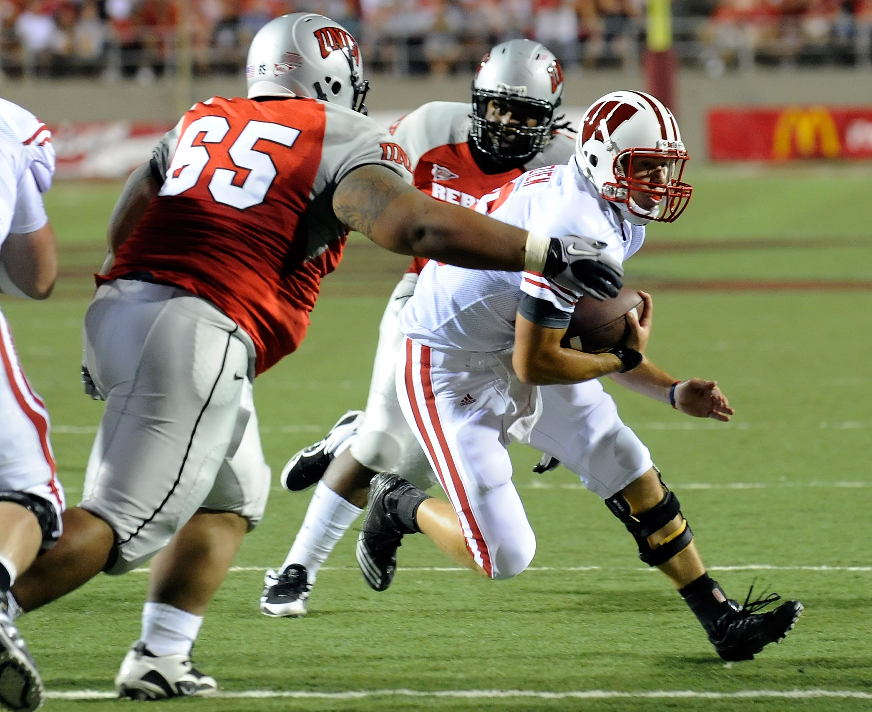 LAS VEGAS - SEPTEMBER 04:  Quarterback Scott Tolzien #16 of the Wisconsin Badgers runs against Ramsey Feagai #65 of the UNLV Rebels during the second quarter of their game at Sam Boyd Stadium September 4, 2010 in Las Vegas, Nevada. Wisconsin won 41-21.  (