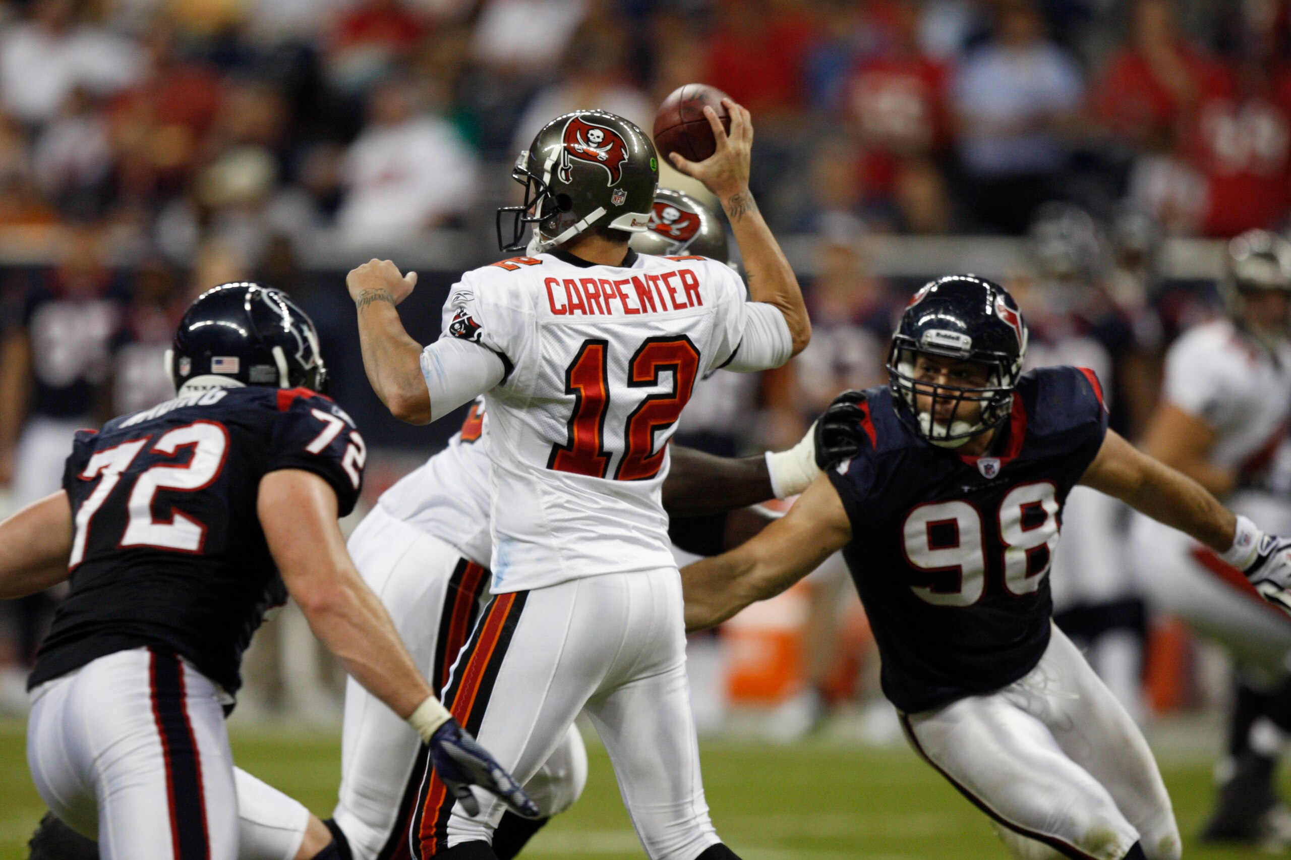 HOUSTON - SEPTEMBER 02:  Quarterback Rudy Carpenter #12 of the Tampa Bay Buccaneers stands in the pocket as he is pressured by defensive ends Jesse Nading #72 and Connor Barwin #98 of the Houston Texans at Reliant Stadium on September 2, 2010 in Houston,