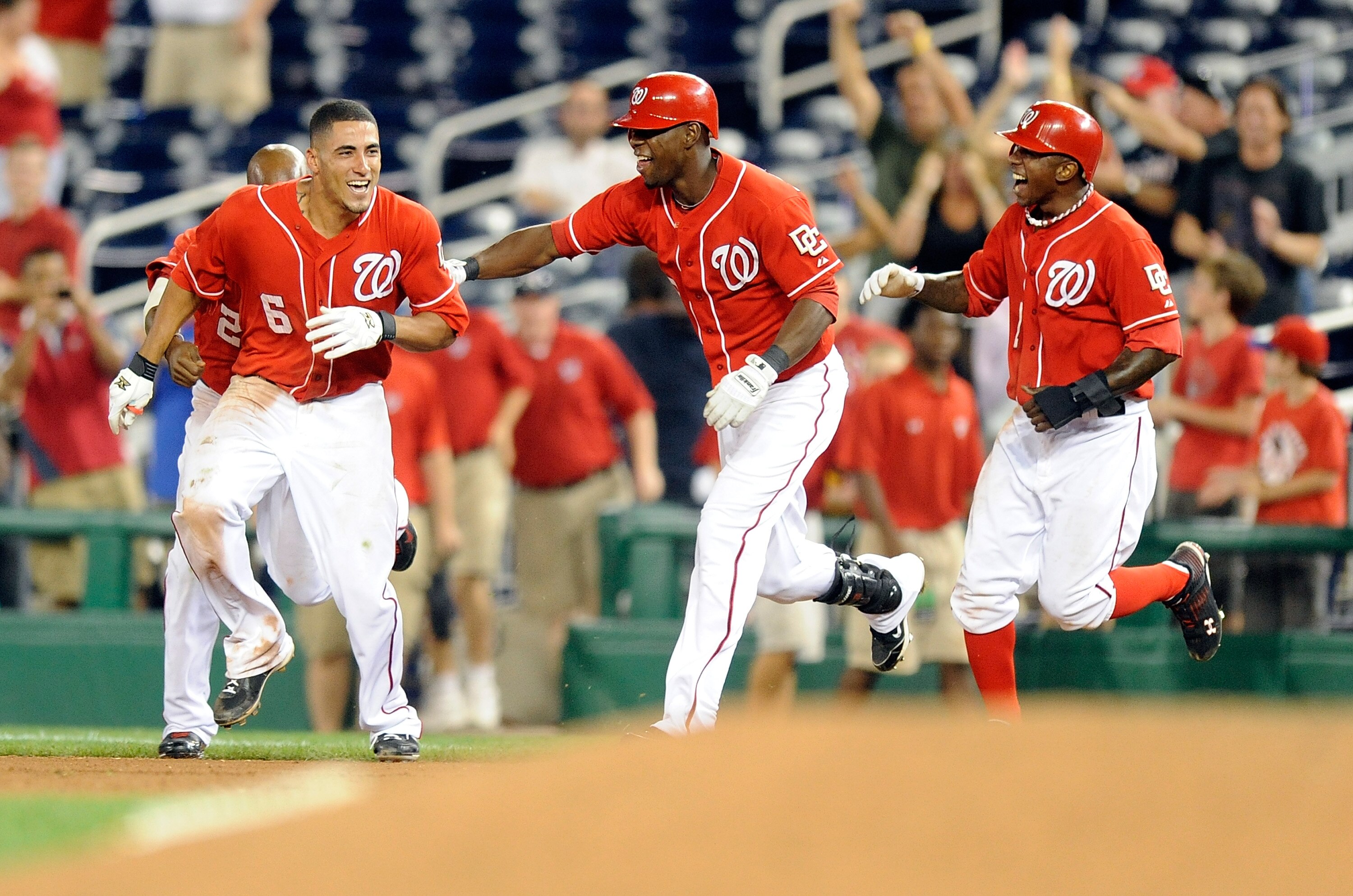 WASHINGTON - AUGUST 26:  Ian Desmond #6 of the Washington Nationals celebrates with Roger Bernadina #2 and Nyjer Morgan #1 after driving in the game winning run in the thirteenth inning against the St. Louis Cardinals at Nationals Park on August 26, 2010