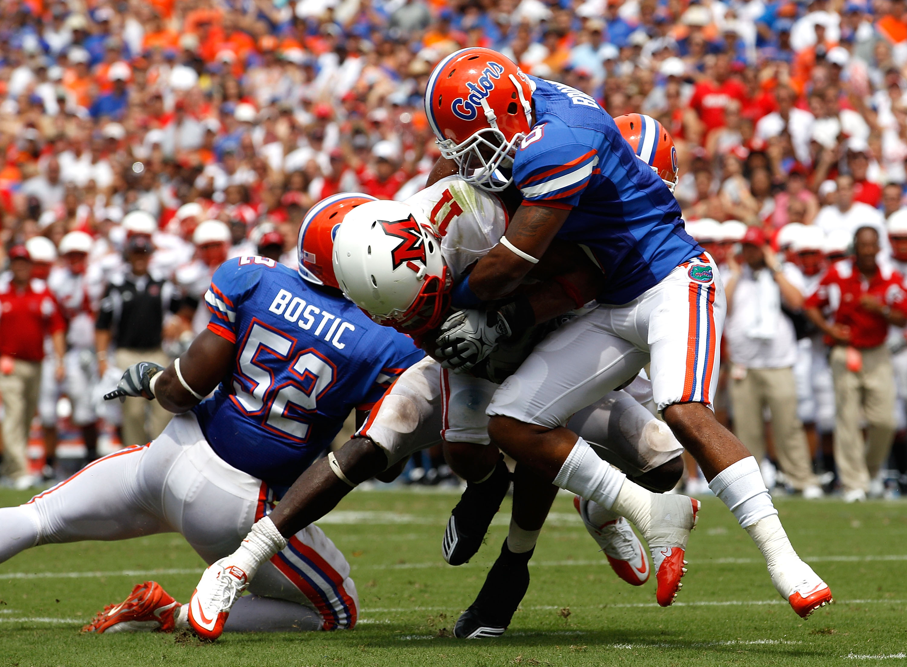 GAINESVILLE, FL - SEPTEMBER 04: Armand Robinson #11 of the Miami University RedHawks is tackled by Johnathan Bostic #52 and Jeremy Brown #8 of the Florida Gators at Ben Hill Griffin Stadium on September 4, 2010 in Gainesville, Florida. (Photo by Sam Gre GAINESVILLE, FL - SEPTEMBER 04: Armand Robinson #11 of the Miami University RedHawks is tackled by Johnathan Bostic #52 and Jeremy Brown #8 of the Florida Gators at Ben Hill Griffin Stadium on September 4, 2010 in Gainesville, Florida. (Photo by Sam Gre