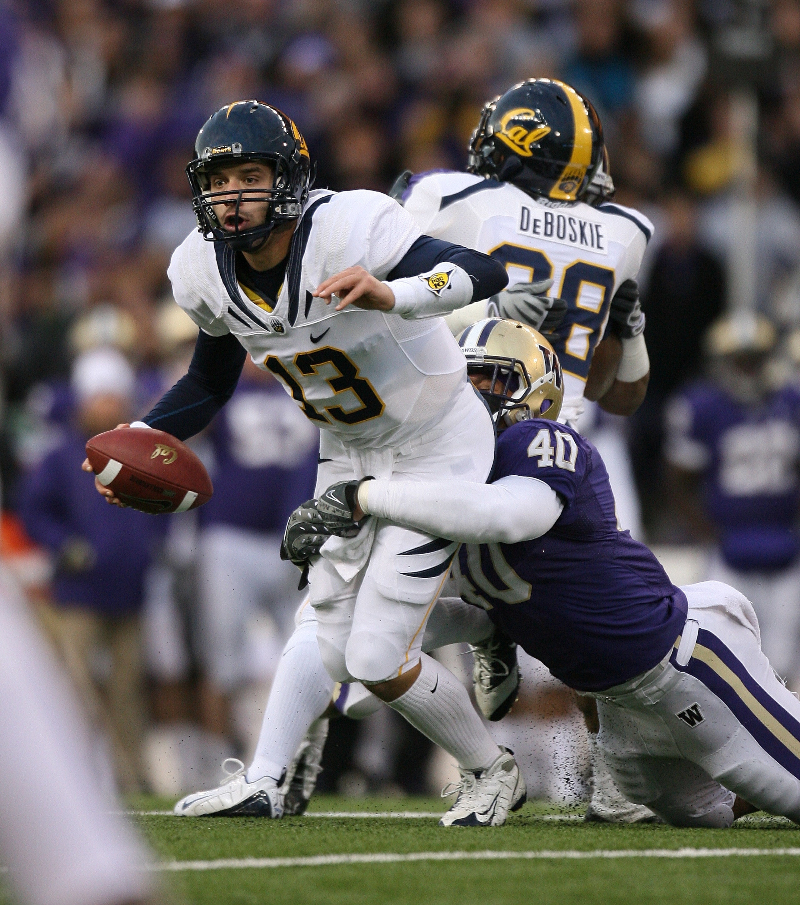 SEATTLE - DECEMBER 05:  Quarterback Kevin Riley #13 of the California Bears scrambles under pressure from Mason Foster #40 of the Washington Huskies on December 5, 2009 at Husky Stadium in Seattle, Washington. (Photo by Otto Greule Jr/Getty Images)