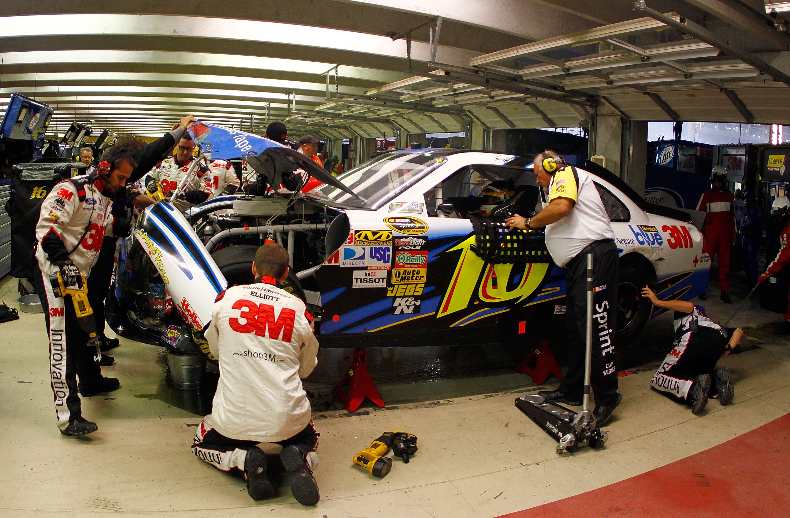 HAMPTON, GA - SEPTEMBER 05:  Greg Biffle, driver of the #16 3M Scotch Blue Ford, talks to a NASCAR official as crew members work on his car in the garage after an incident in the NASCAR Sprint Cup Series Emory Healthcare 500 at Atlanta Motor Speedway on S