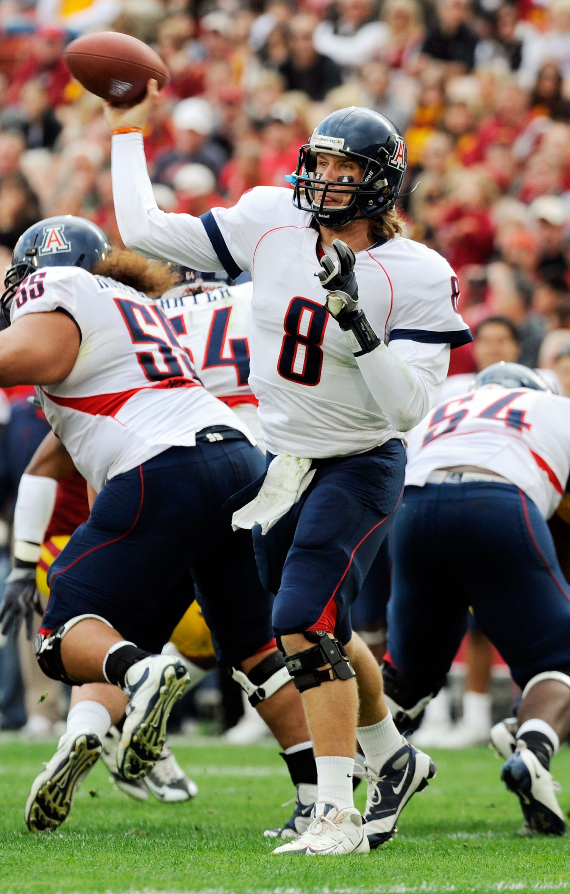 LOS ANGELES, CA - DECEMBER 05:  Quarterback Nick Foles #8 of the Arizona Wildcats completes a pass against the USC Trojans during the first quarter of the NCAA college football game at the Los Angeles Coliseum on December 5, 2009 in Los Angeles, Californi
