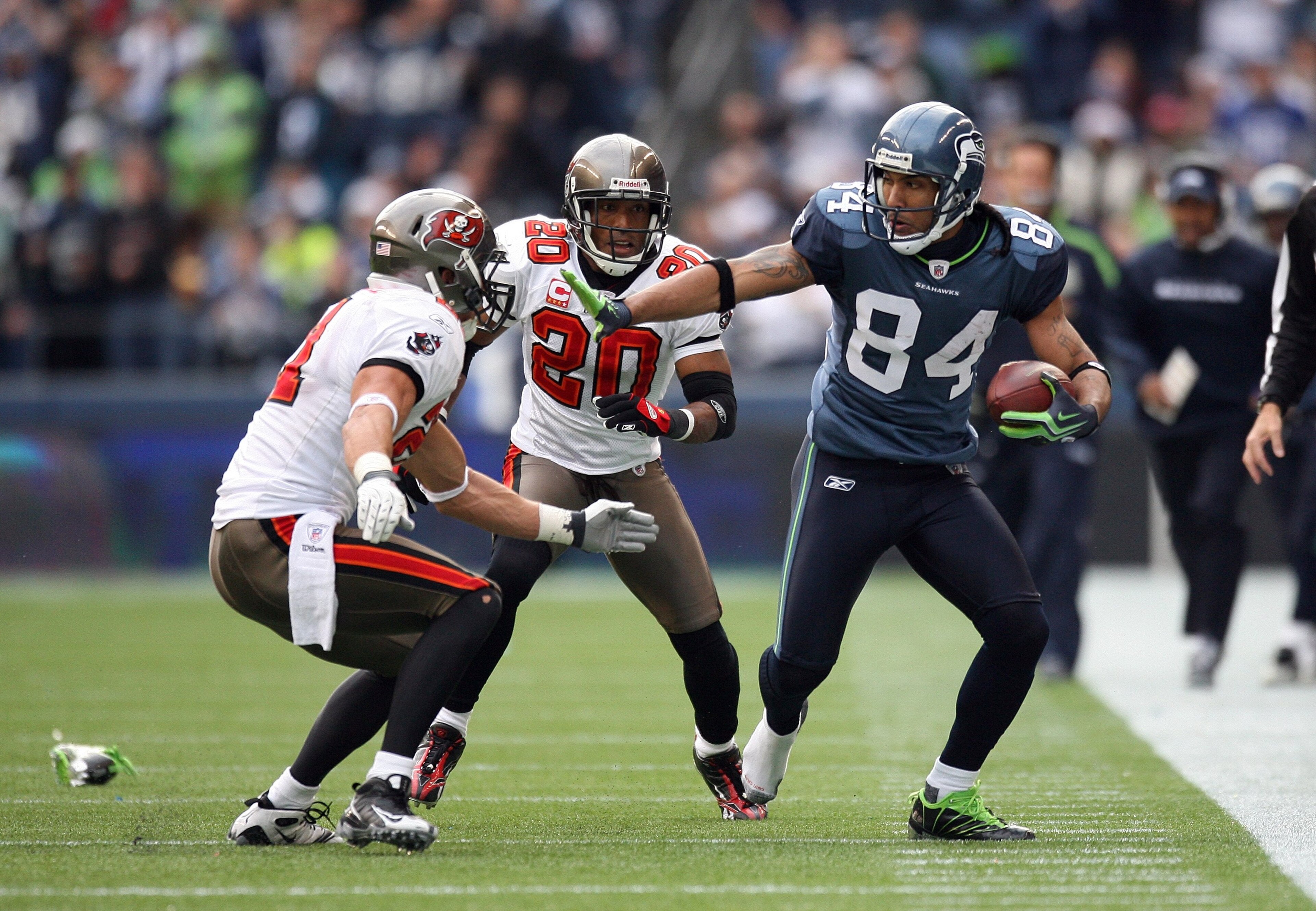 SEATTLE - DECEMBER 20: T.J. Houshmandzadeh #84 of the Seattle Seahawks looks to straight-arm Sabby Piscitelli #21 of the Tampa Bay Buccaneers during their game on December 20, 2009 at Qwest Field in Seattle, Washington. The Buccaneers defeated the Seahaw SEATTLE - DECEMBER 20: T.J. Houshmandzadeh #84 of the Seattle Seahawks looks to straight-arm Sabby Piscitelli #21 of the Tampa Bay Buccaneers during their game on December 20, 2009 at Qwest Field in Seattle, Washington. The Buccaneers defeated the Seahaw