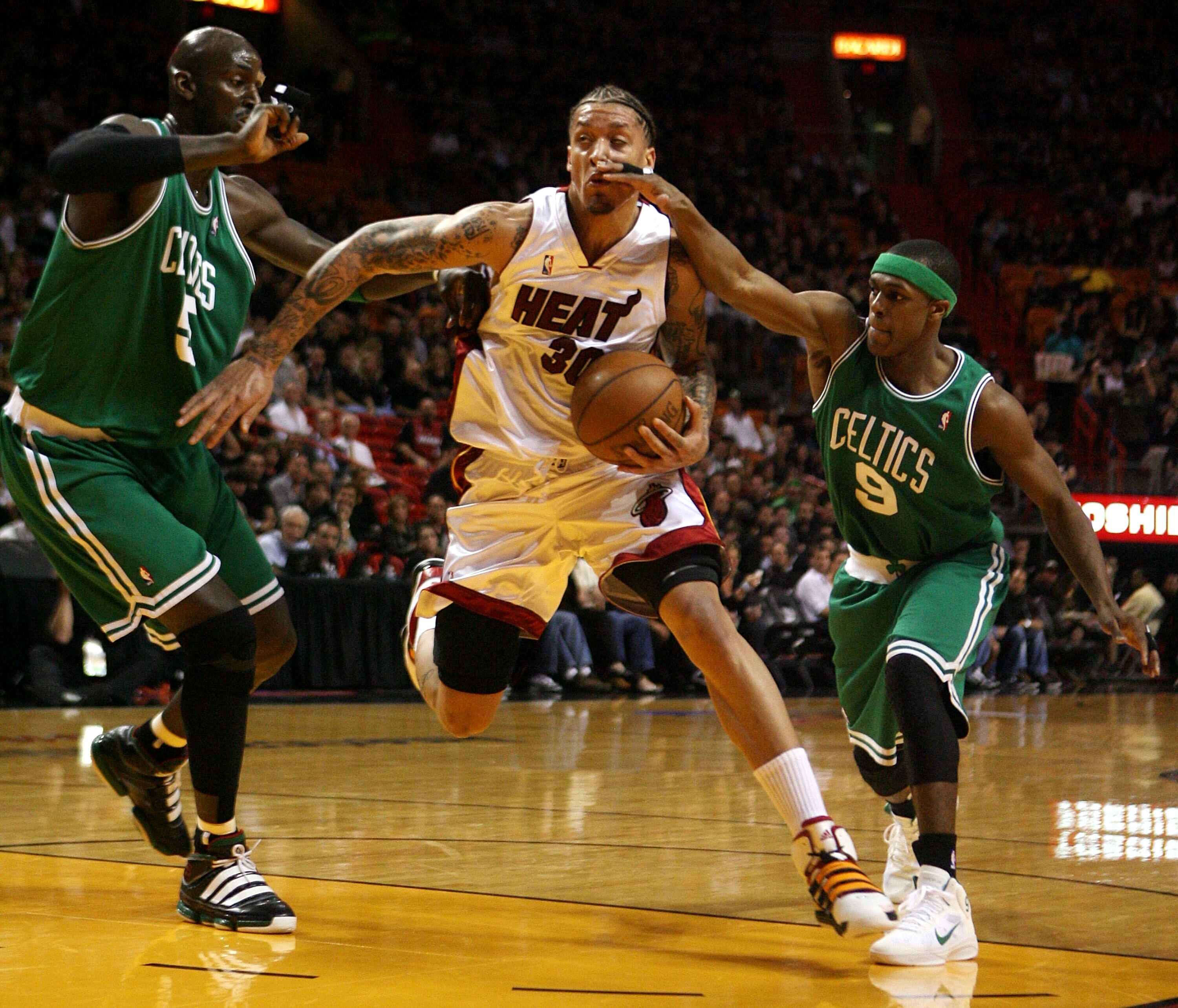 MIAMI - APRIL 23: Forward Kevin Garnett #5 and guard Rajon Rondo #9 of the Boston Celtics defend forward Michael Beasley #30 of the Miami Heat in Game Three of the Eastern Conference Quarterfinals during the 2010 NBA Playoffs at American Airlines Arena on