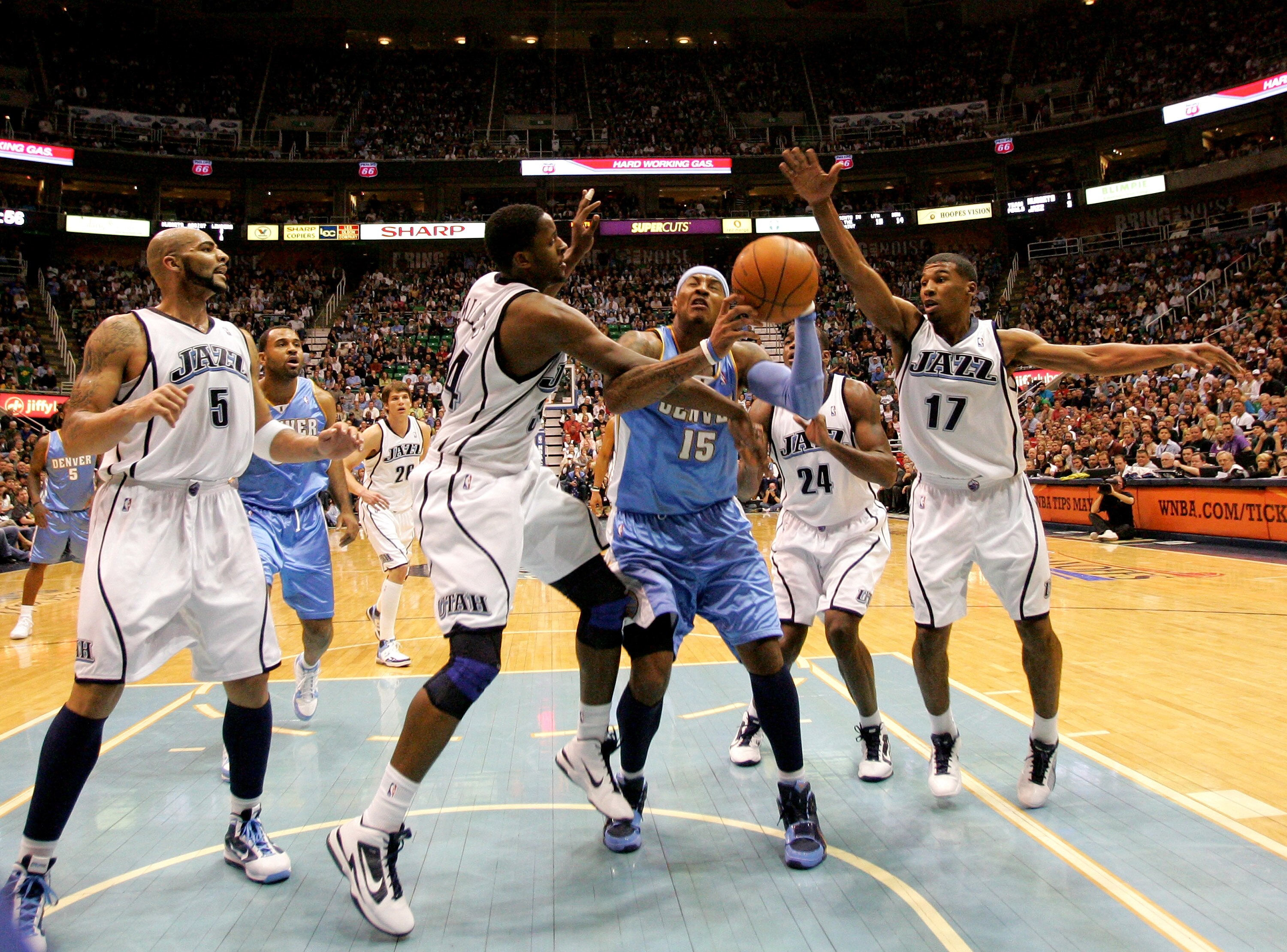 SALT LAKE CITY - APRIL 30:  Carmelo Anthony #15 of the Denver Nuggets is fouled by C.J. Miles #34 of the Utah Jazz in Game Six of the Western Conference Quarterfinals of the 2010 NBA Playoffs at EnergySolutions Arena on April 30, 2010 in Salt Lake City, U