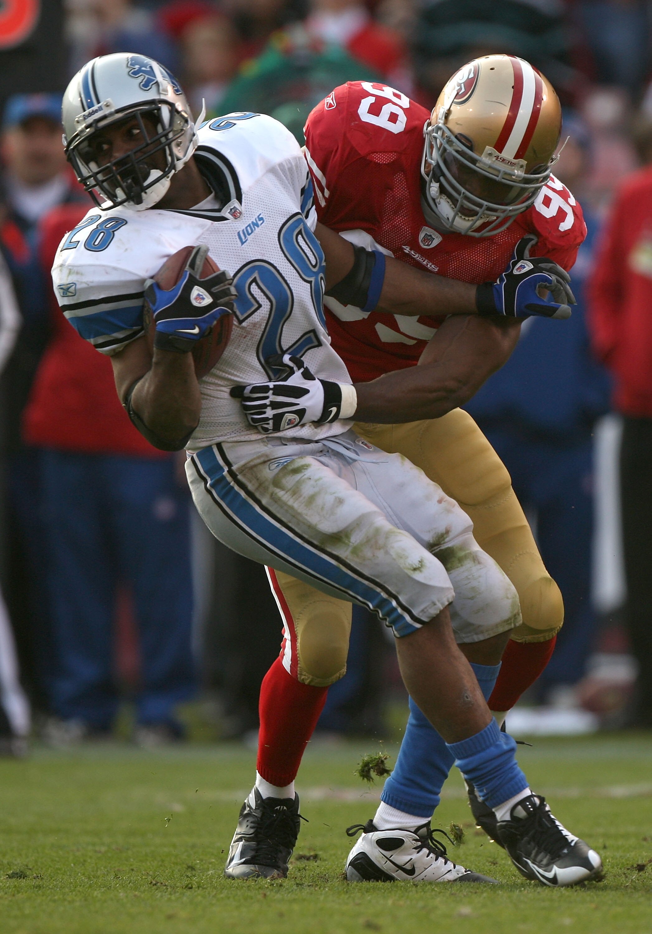 SAN FRANCISCO - DECEMBER 27:  Manny Lawson #99 of the San Francisco 49ers tackles Maurice Morris #28 of the Detroit Lions during an NFL game at Candlestick Park on December 27, 2009 in San Francisco, California.  (Photo by Jed Jacobsohn/Getty Images)