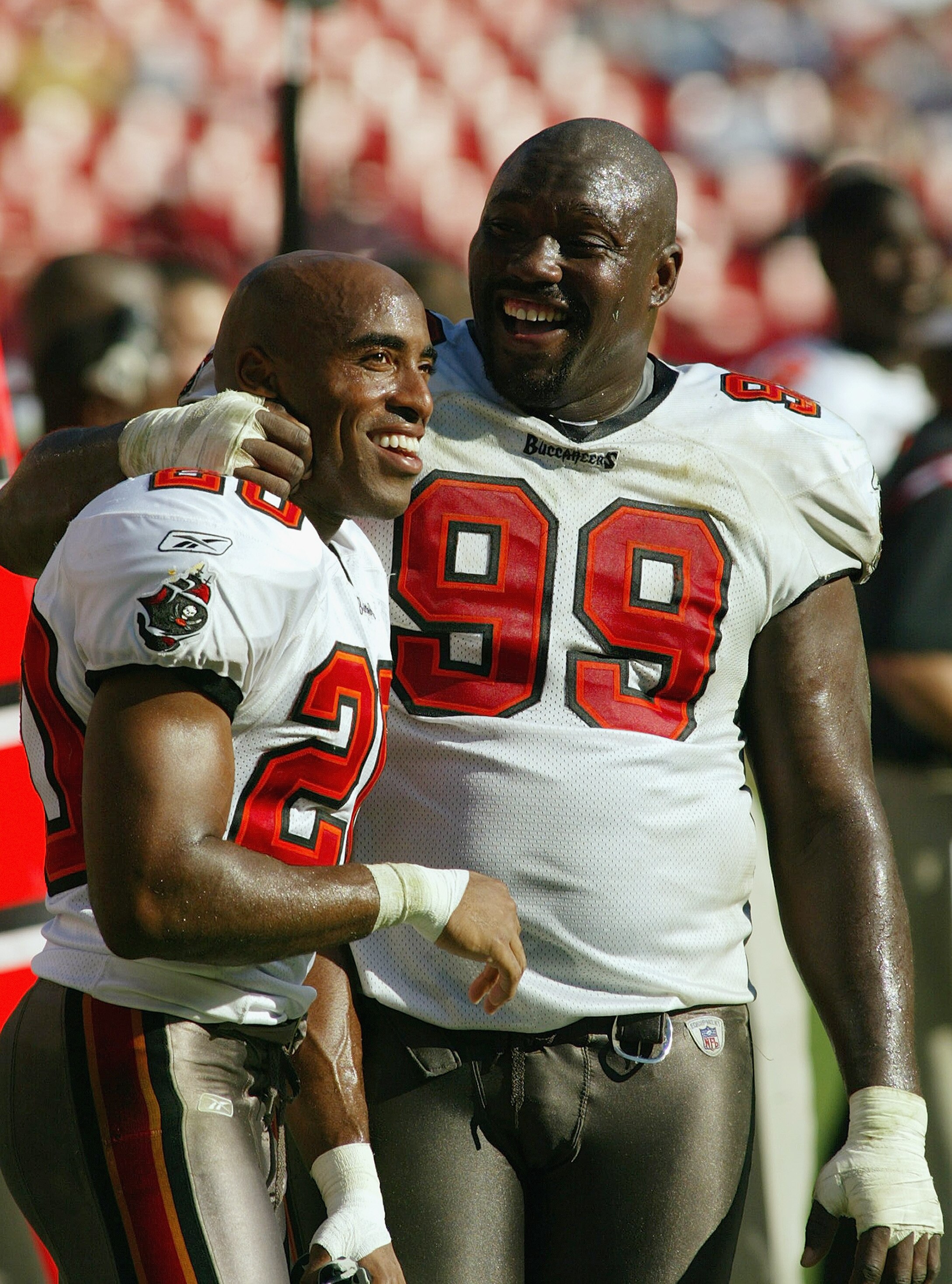 LANDOVER, MD - OCTOBER 12:   Left tackle Warren Sapp #99 and cornerback Ronde Barber #20 of the Tampa Bay Buccaneers smile on the sideline during a game against the Washington Redskins on October 12, 2003 at FedEx Field in Landover, Maryland. The Bucs won