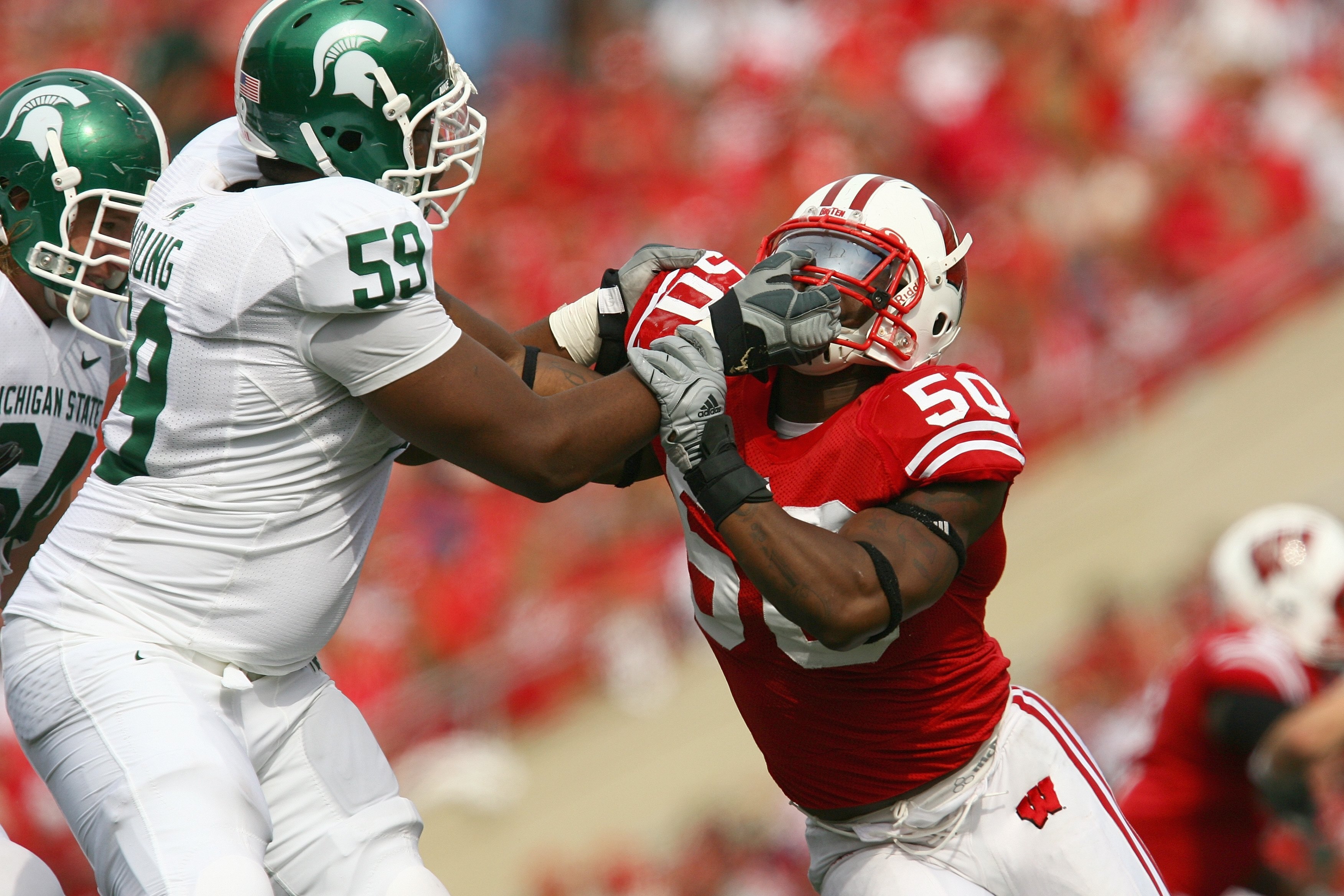 MADISON, WI - SEPTEMBER 26: O'Brien Schofield #50 of the Wisconsin Badgers gets a facemask from D.J. Young #59 of the Michigan State Spartans on September 26, 2009 at Camp Randall Stadium in Madison, Wisconsin. Wisconsin defeated Michigan State 38-30. (Ph
