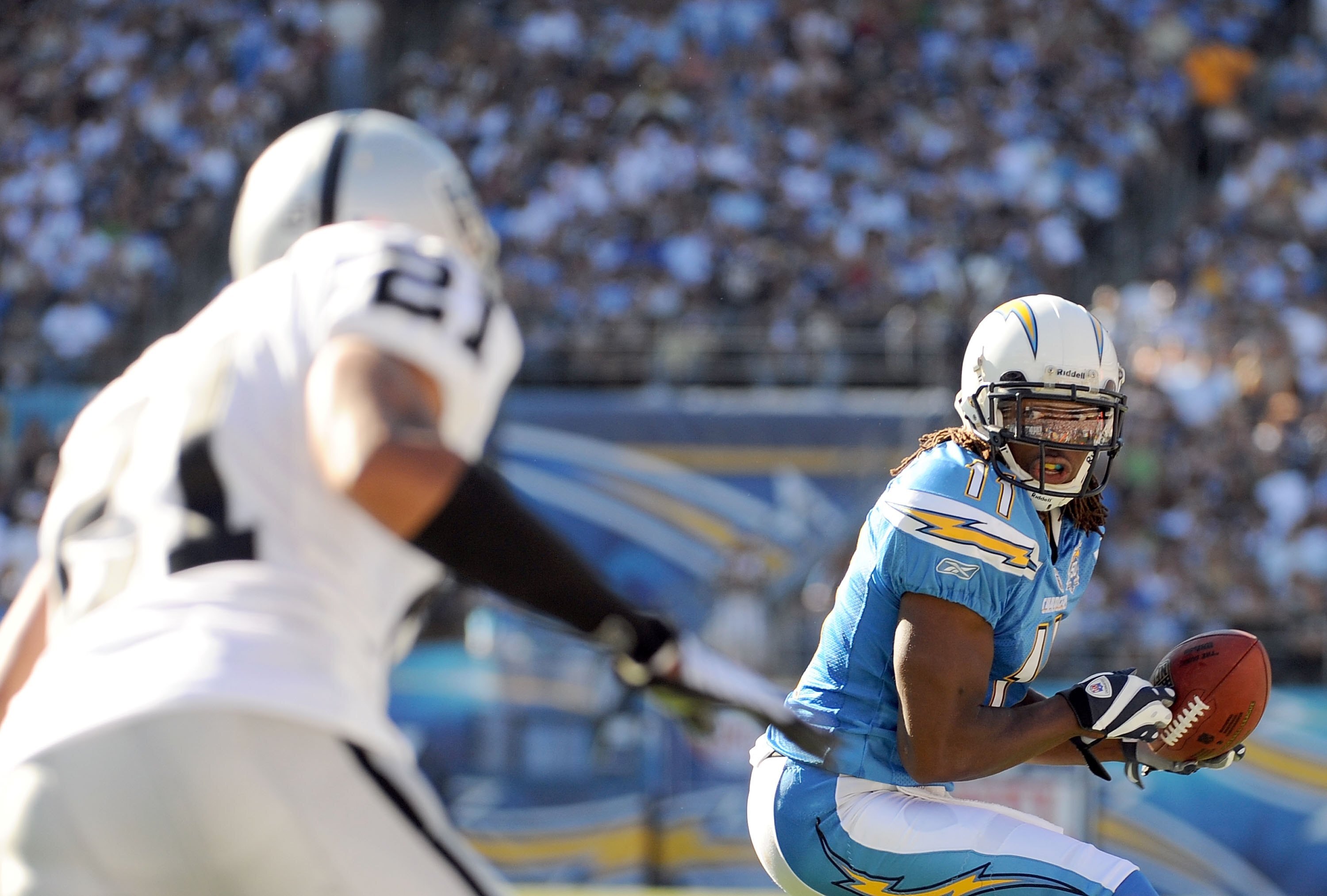 SAN DIEGO - NOVEMBER 01:  Legedu Naanee #11 of the San Diego Chargers looks to run after his catch in front of Nnamdi Asomugha #21 of the Oakland Raiders during the second quarter at Qualcomm Stadium on November 1, 2009 in San Diego California. The Charge