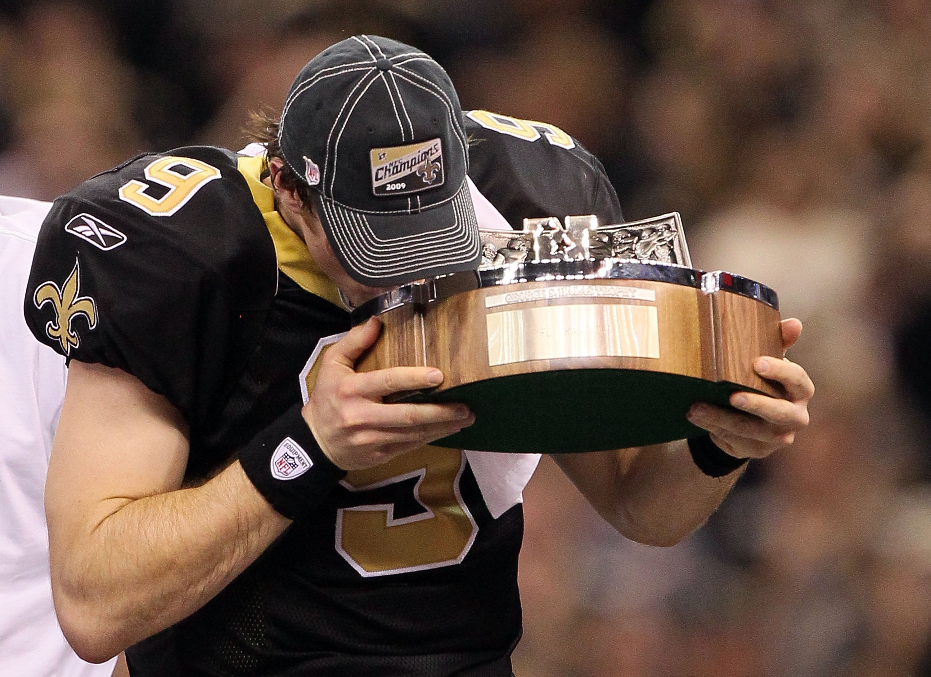 NEW ORLEANS - JANUARY 24:  Quarterback Drew Brees #9 of the New Orleans Saints kisses the George S. Halas trophy after the Saints won 31-28 in overtime against the Minnesota Vikings during the NFC Championship Game at the Louisiana Superdome on January 24